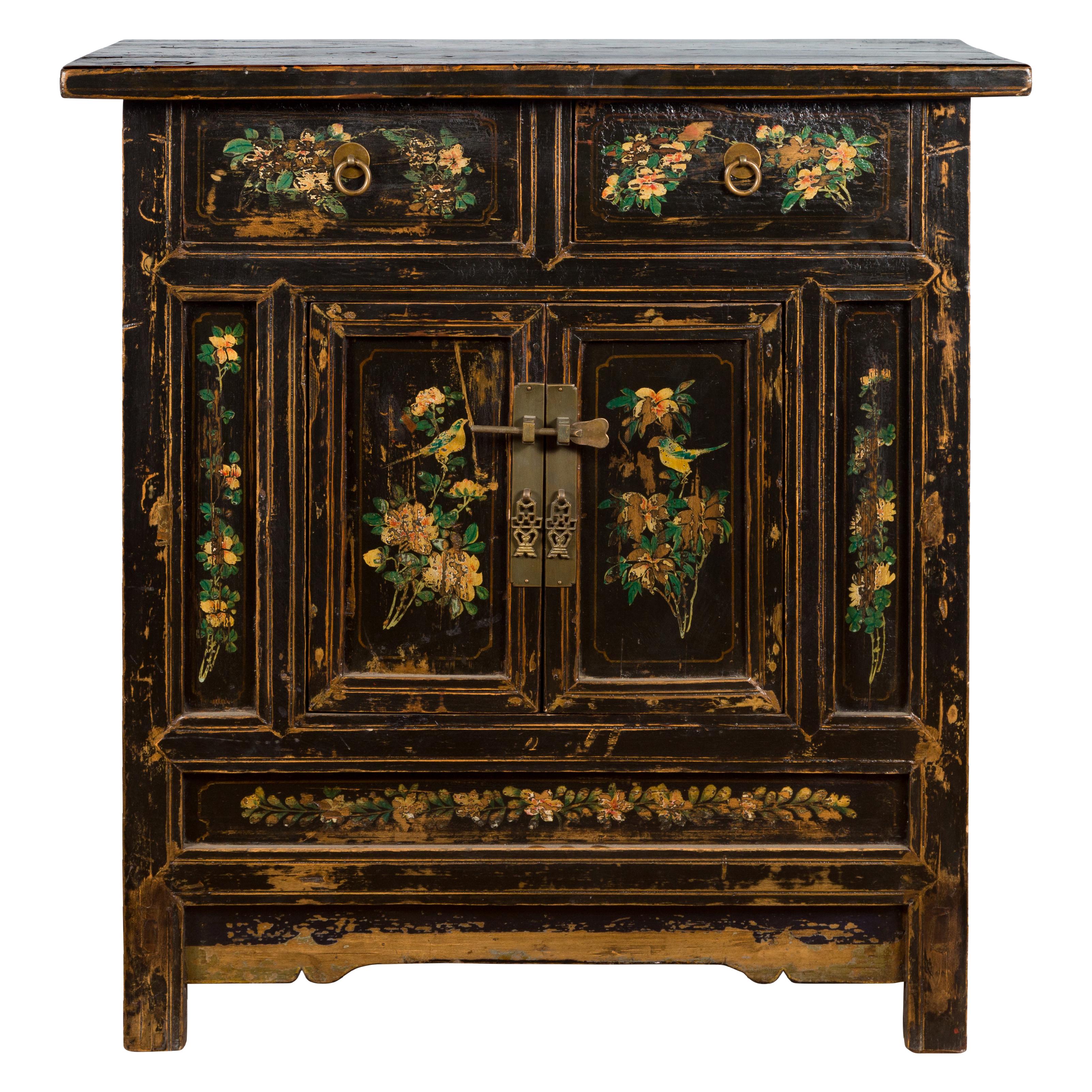 A Chinese Qing Dynasty period painted wood cabinet from the 19th century, with floral décor and brass hardware. Created in China during the 19th century, this painted cabinet features a rectangular top sitting above two drawers followed by two