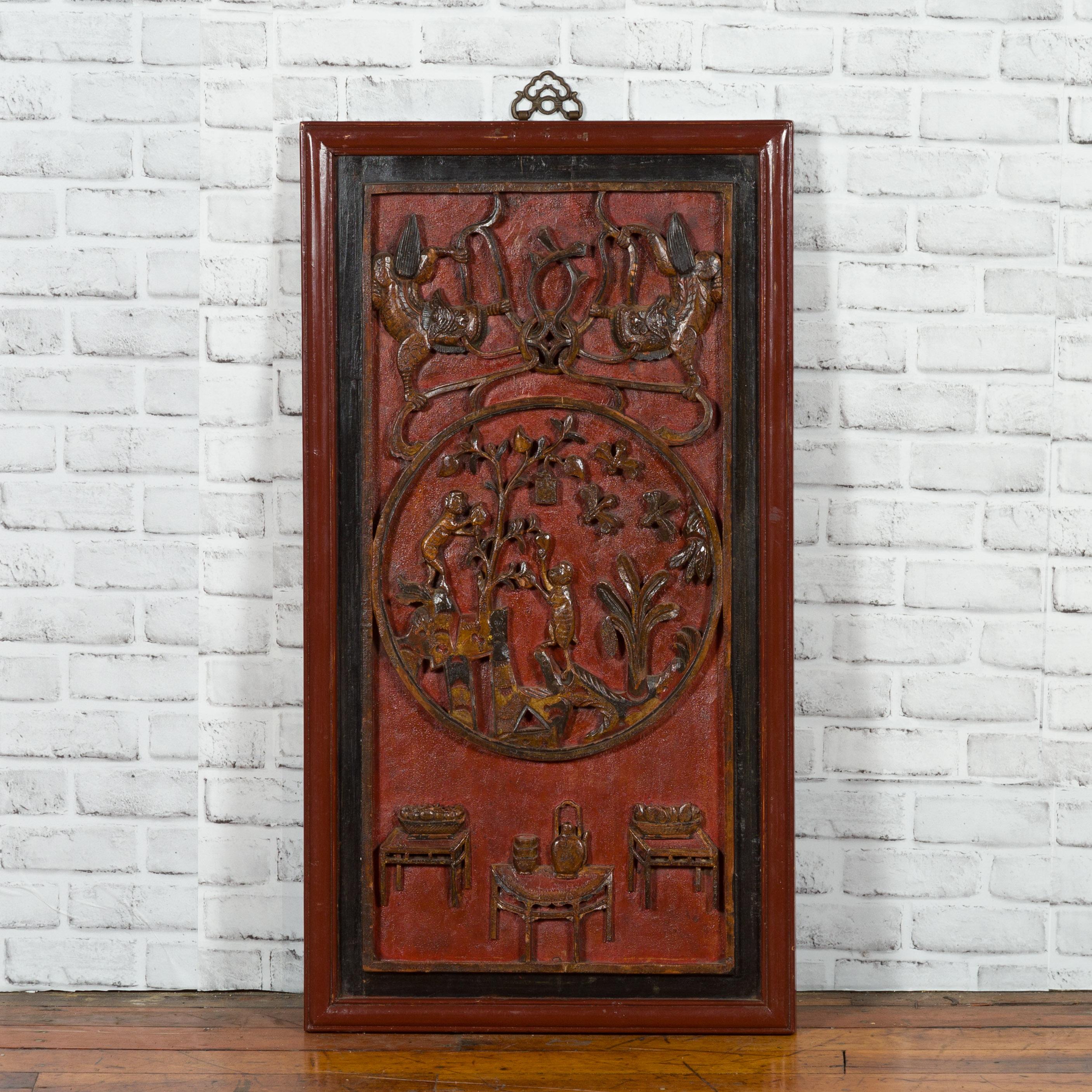 A Chinese Qing Dynasty period architectural panel from the 19th century, with carved monkeys and red, black and brown lacquer. Created in China during the Qing Dynasty, this wall hanging architectural panel showcases a subtle polychromy mixing red,