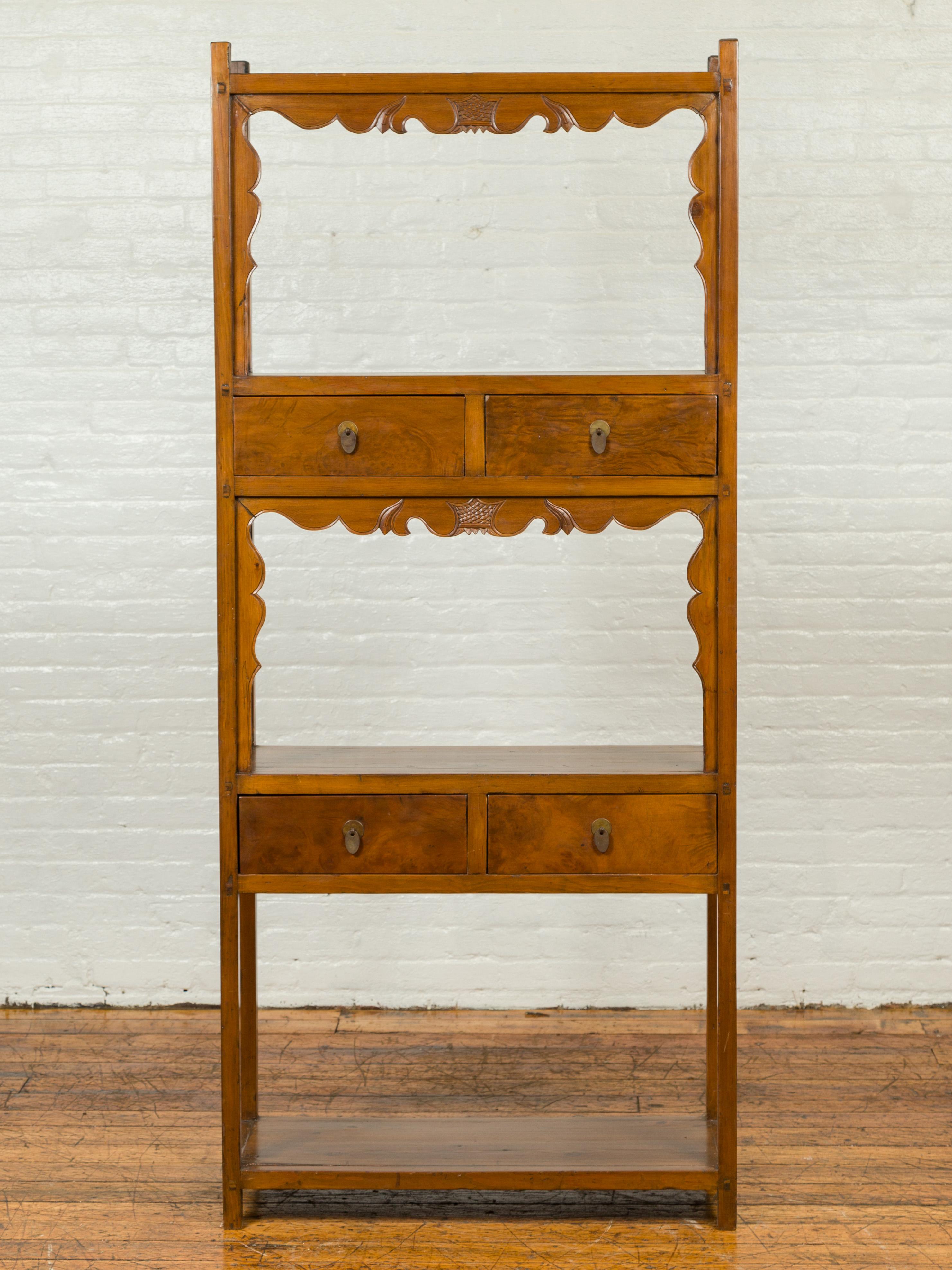 A Chinese Qing dynasty elmwood bookcase from the 19th century, with three open shelves and four drawers. Born in China during the Qing dynasty period, this elm bookcase features three open shelving areas, two of which are accented with scrolling