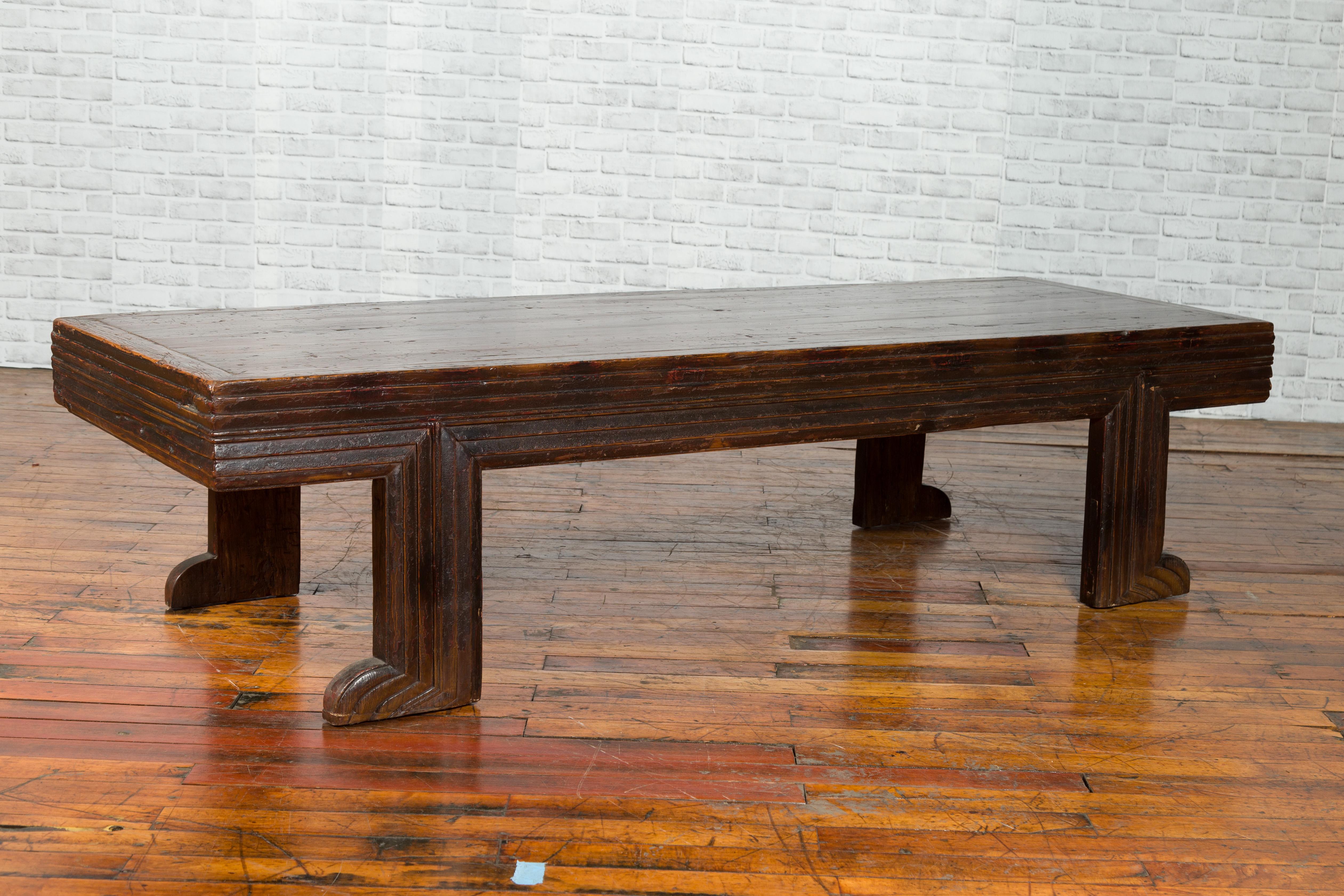 A long Chinese Qing dynasty period fine elmwood coffee table from the 19th century with unusual recessed legs and reeded apron. This antique long table comes from China, where it was made during the 19th century with fine elmwood. The Chinese didn't