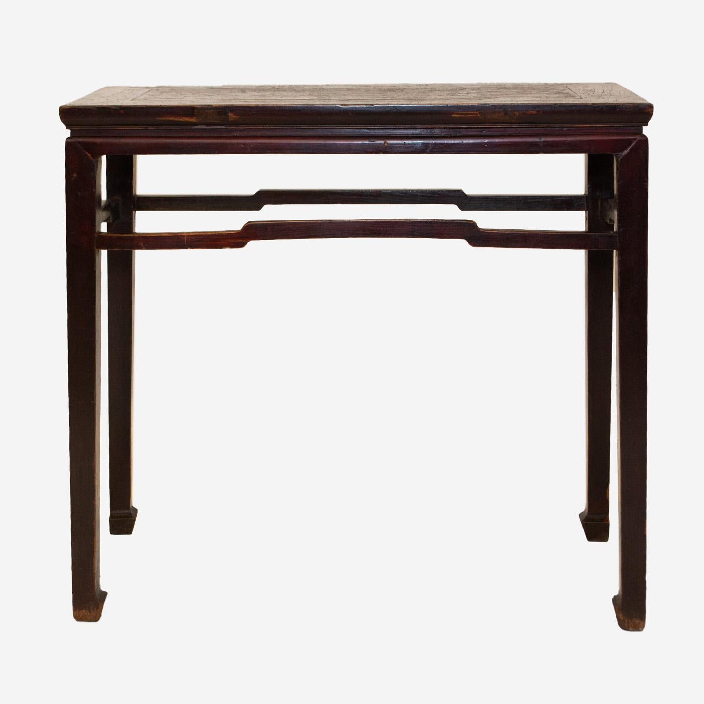 Created in China during the Qing Dynasty, this 19th century Elmwood wine console table features a rectangular top with central board, sitting above a waisted apron. Raised on four straight legs with horse hoof feet connected to one another through
