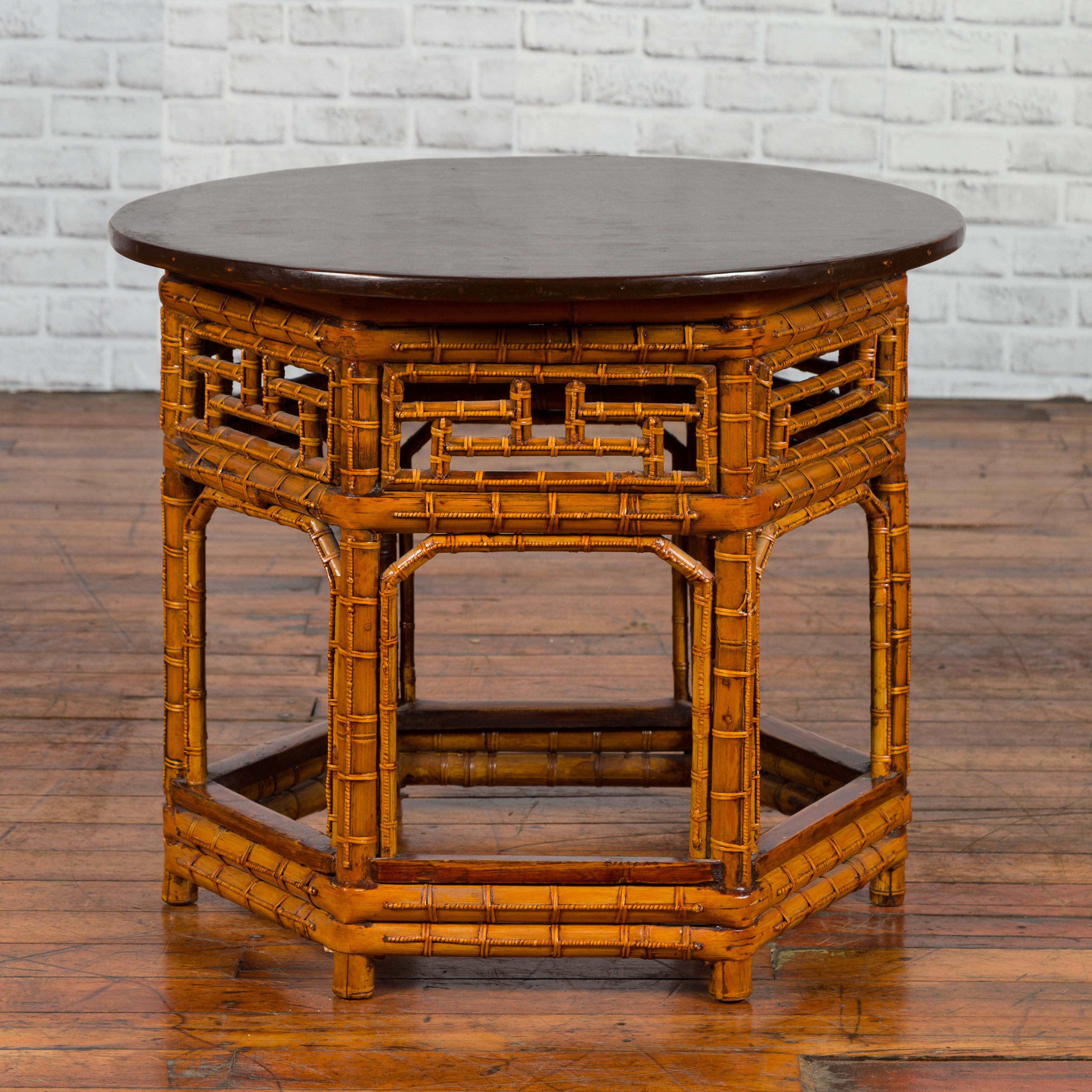 A Chinese Qing Dynasty period hexagonal bamboo and dark brown lacquered side table from the 19th century, with intricate motifs. Created in China during the Qing Dynasty period, this side table features a circular dark brown lacquered top sitting