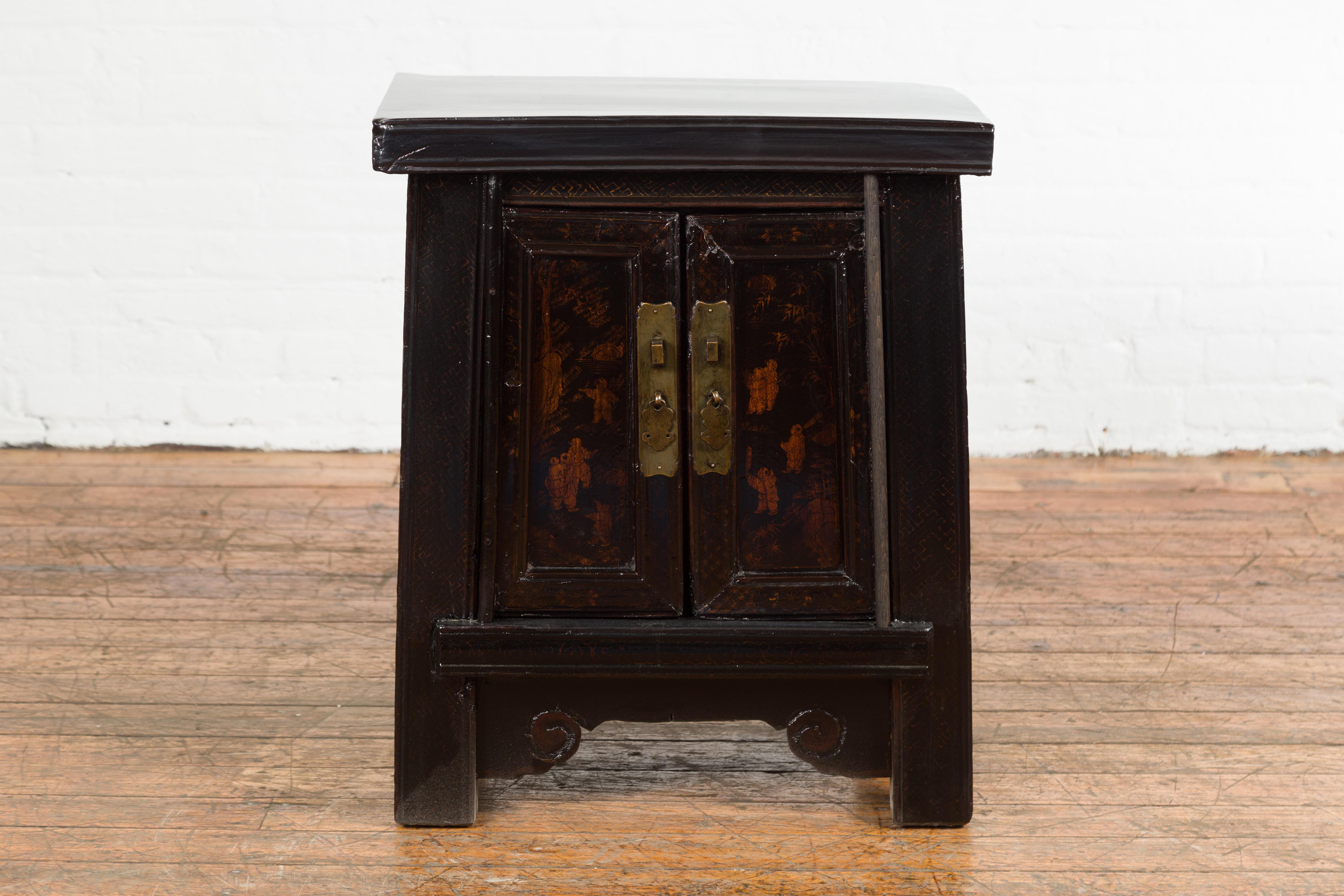 A Chinese Qing Dynasty period bedside cabinet from the 19th century with dark lacquer, hand-painted scenes on the doors and brass hardware. Invite a touch of ethereal elegance to your bedroom with this exquisite 19th-century Chinese Qing Dynasty