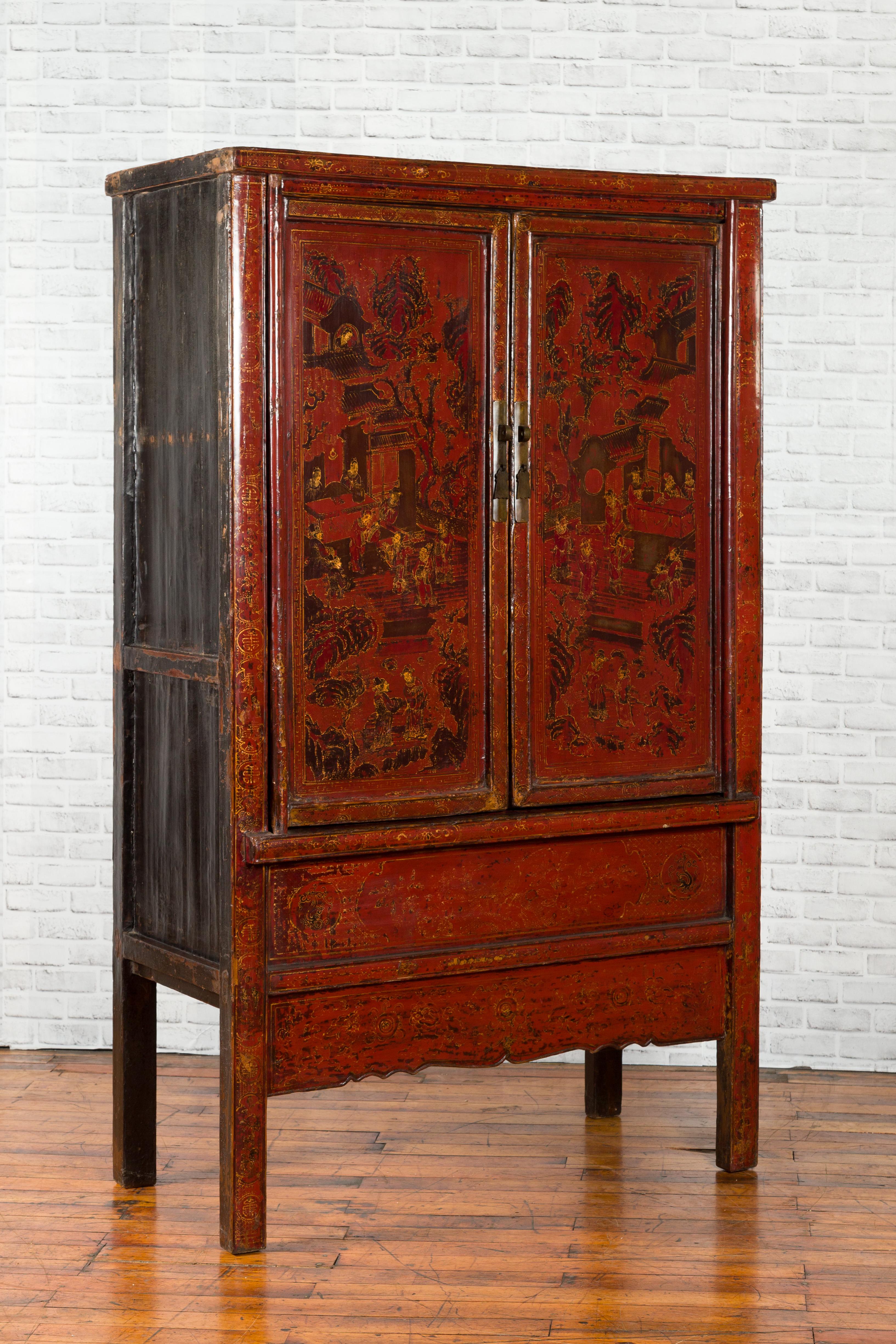 A Chinese Qing Dynasty period red cabinet from the 19th century with hand painted Chinoiserie decor and gilt accents. Created in China during the Qing Dynasty, this cabinet features two doors, adorned with court scenes, opening to reveal inner