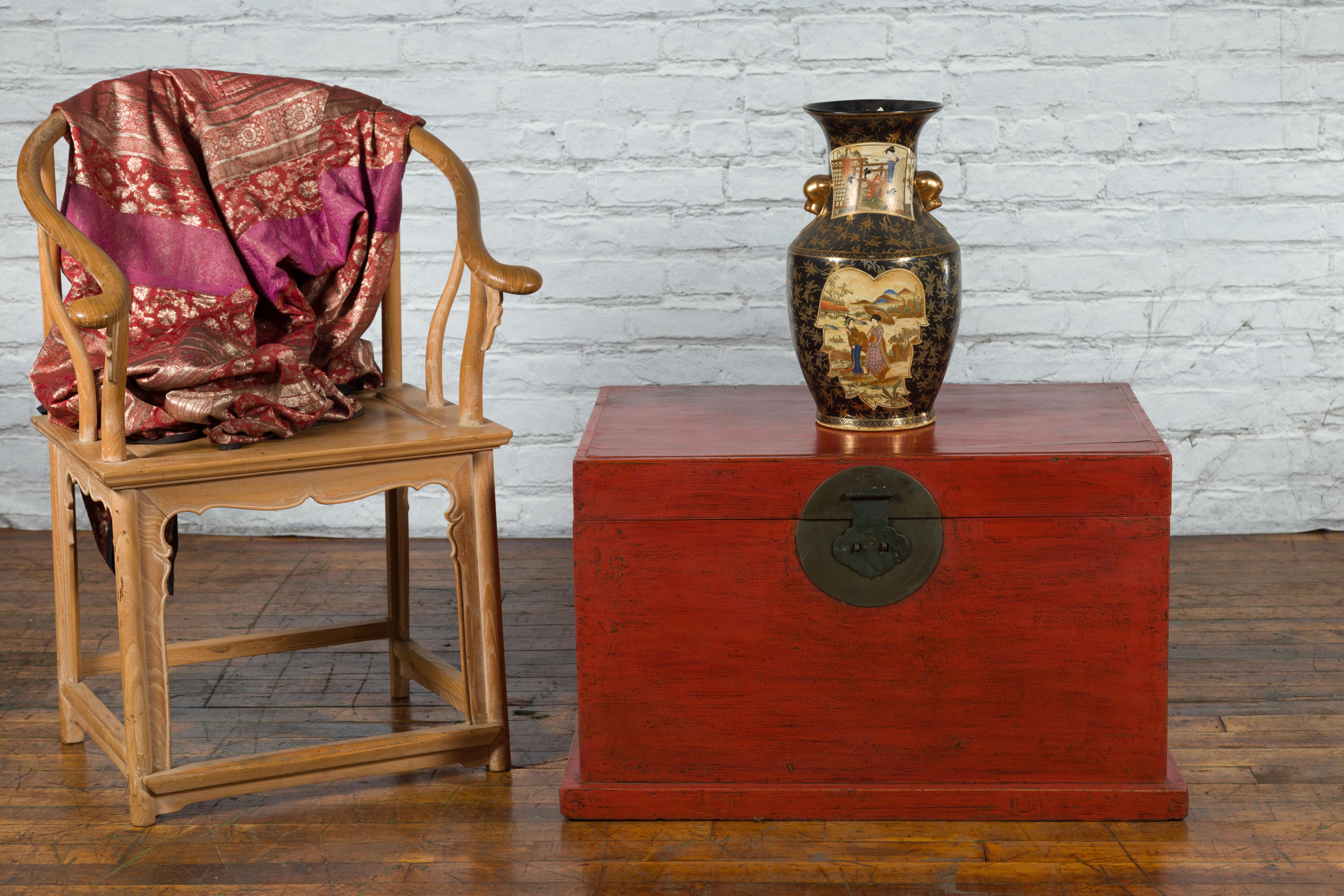 A Chinese Qing Dynasty period red lacquered trunk from the 19th century, with round metal hardware. Created in China during the 19th century, this red lacquered trunk features a rectangular lid opening thanks to a traditional brass medallion lock,