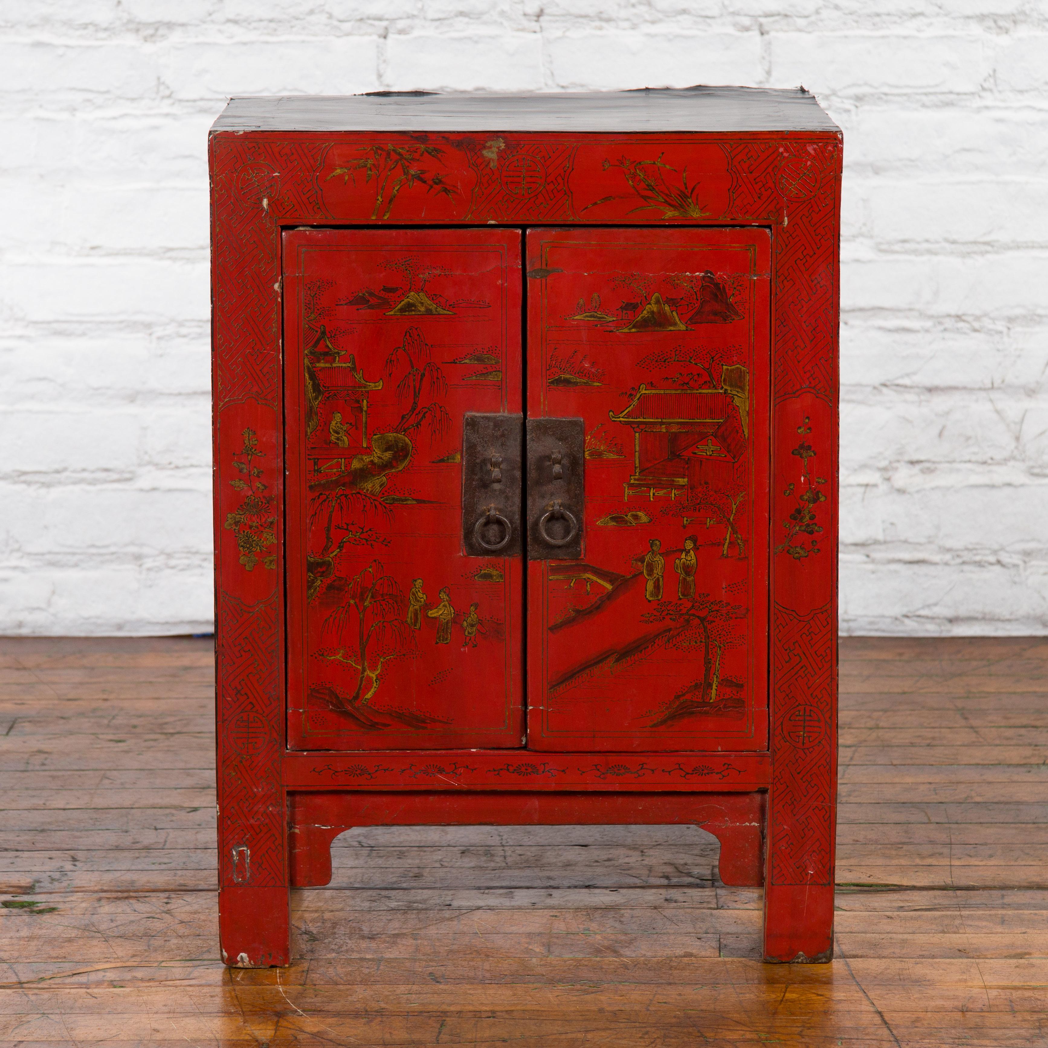 A Chinese Qing Dynasty period red lacquer side cabinet from the 19th century, with golden Chinoiserie décor. Created in China during the Qing Dynasty, this side cabinet features a red lacquered façade perfectly accented by a delicate golden