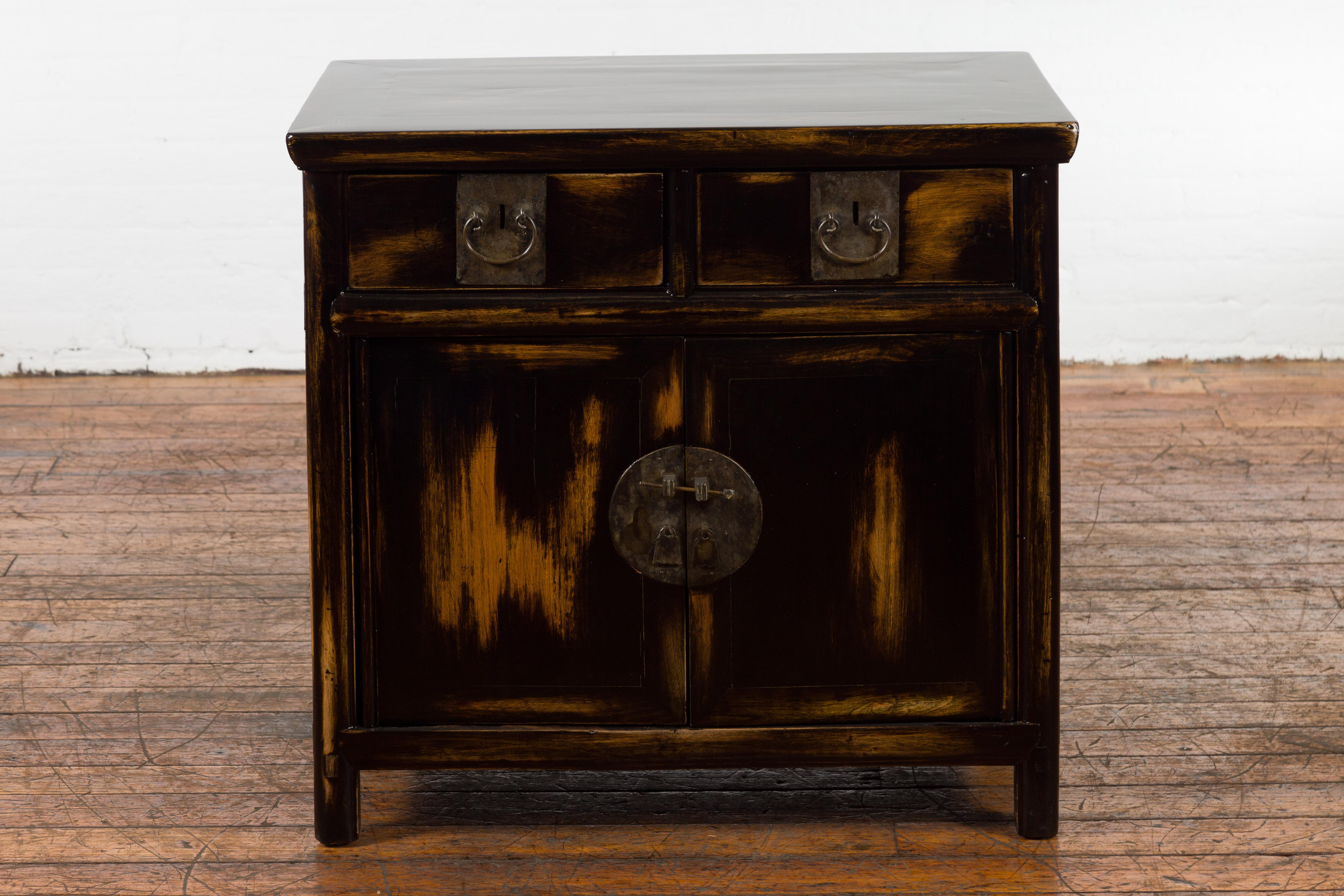 A Chinese Qing Dynasty period side cabinet from the 19th century with custom black and brown lacquer, two drawers and two doors. Created in China during the Qing Dynasty period in the 19th century, this side cabinet features a rectangular with