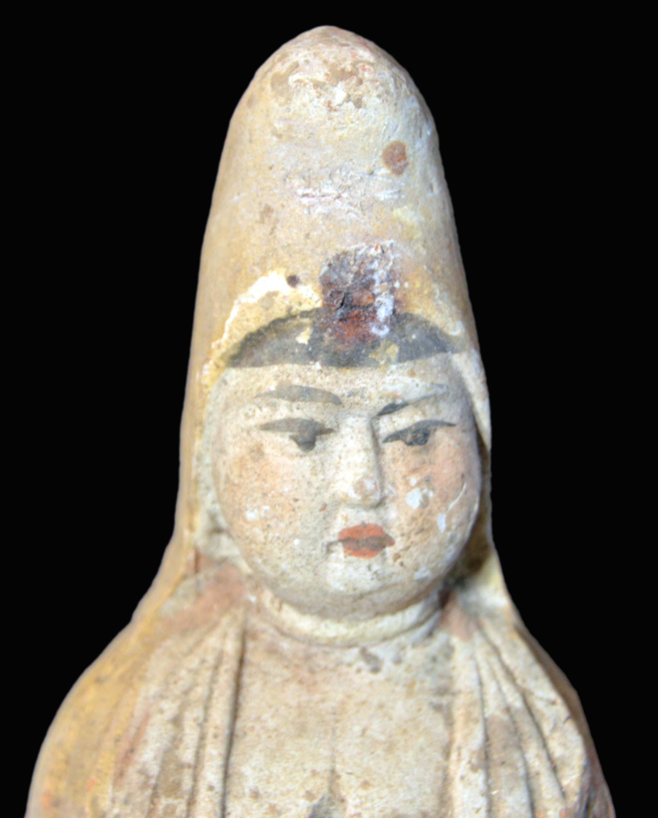 A 19th century Chinese standing priestess sculpture made from terracotta during the later stages of the Qing dynasty with traces of original paint. This small hollow statue displays a standing priestess wearing a dress with a hood. The round face