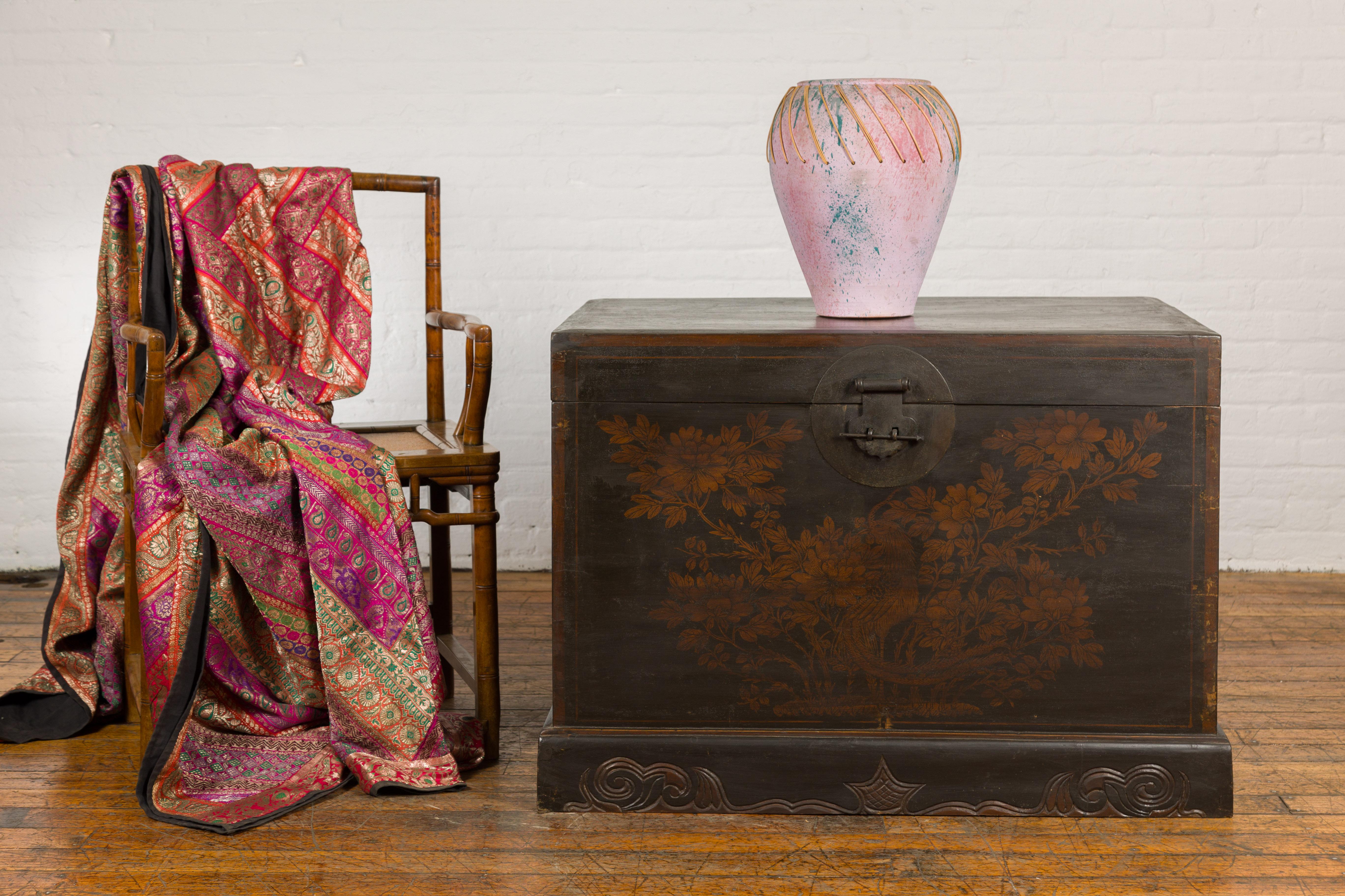 A Chinese Qing Dynasty period black and brown lacquer blanket chest from the 19th century with hand-painted bird and foliage motifs and nicely carved base. Unearth the beauty of Asian craftsmanship with this 19th-century Chinese Qing Dynasty blanket