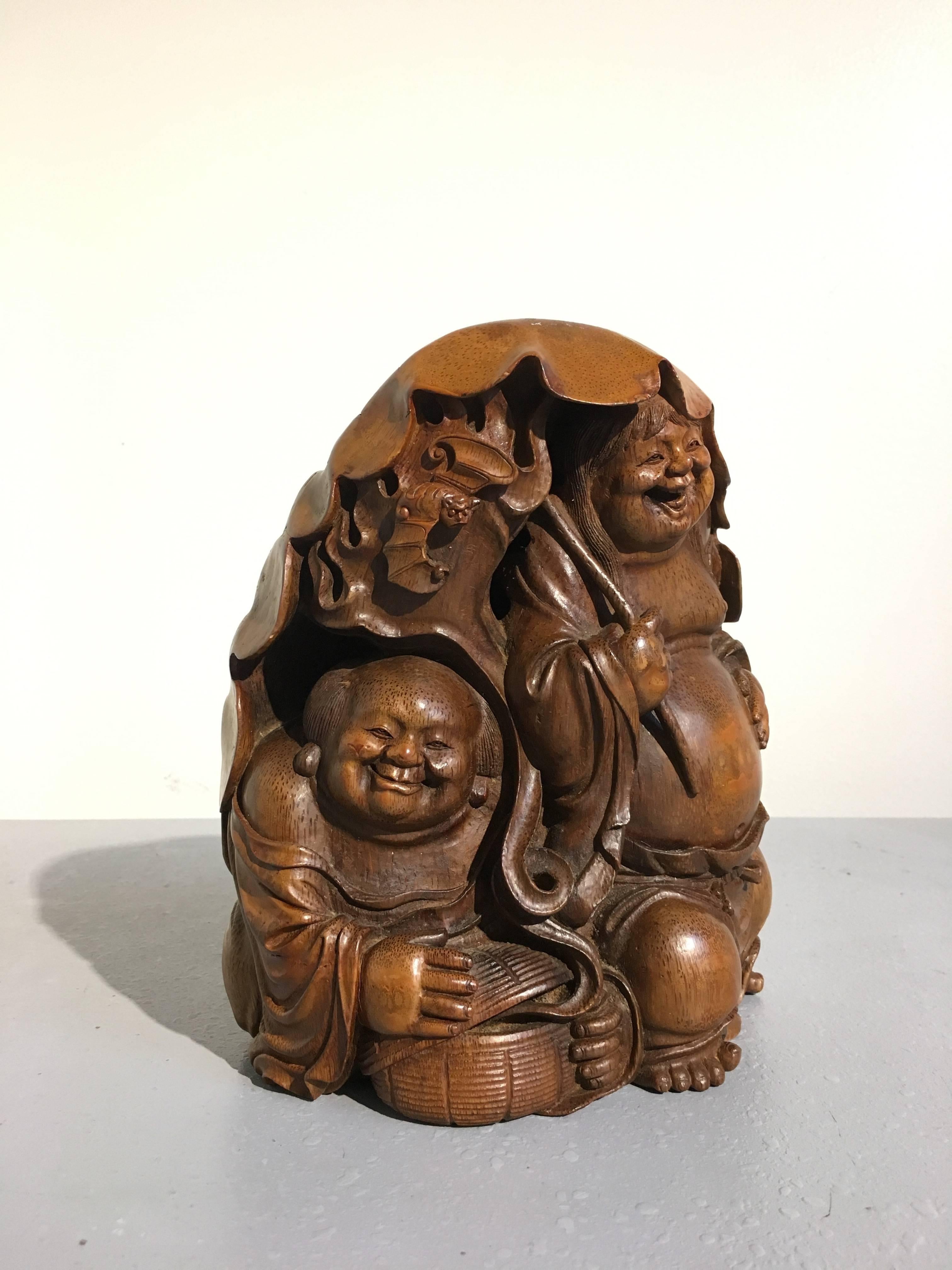 A wonderful Chinese bamboo figural carving featuring the Taoist immortal twins of eternal youth, known as the HeHe ErXian, Qing dynasty, 19th century.

Finely carved from a single large section of bamboo root, the twins of mirth and harmony, often
