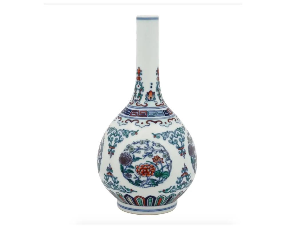 An antique Chinese late Qing Dynasty Doucai porcelain vase. The vase of pear form, the globular body rising to a slender neck and slightly flared mouth. The body is enameled with a continuous lotus, scroll and blossoming flower motifs. The neck is