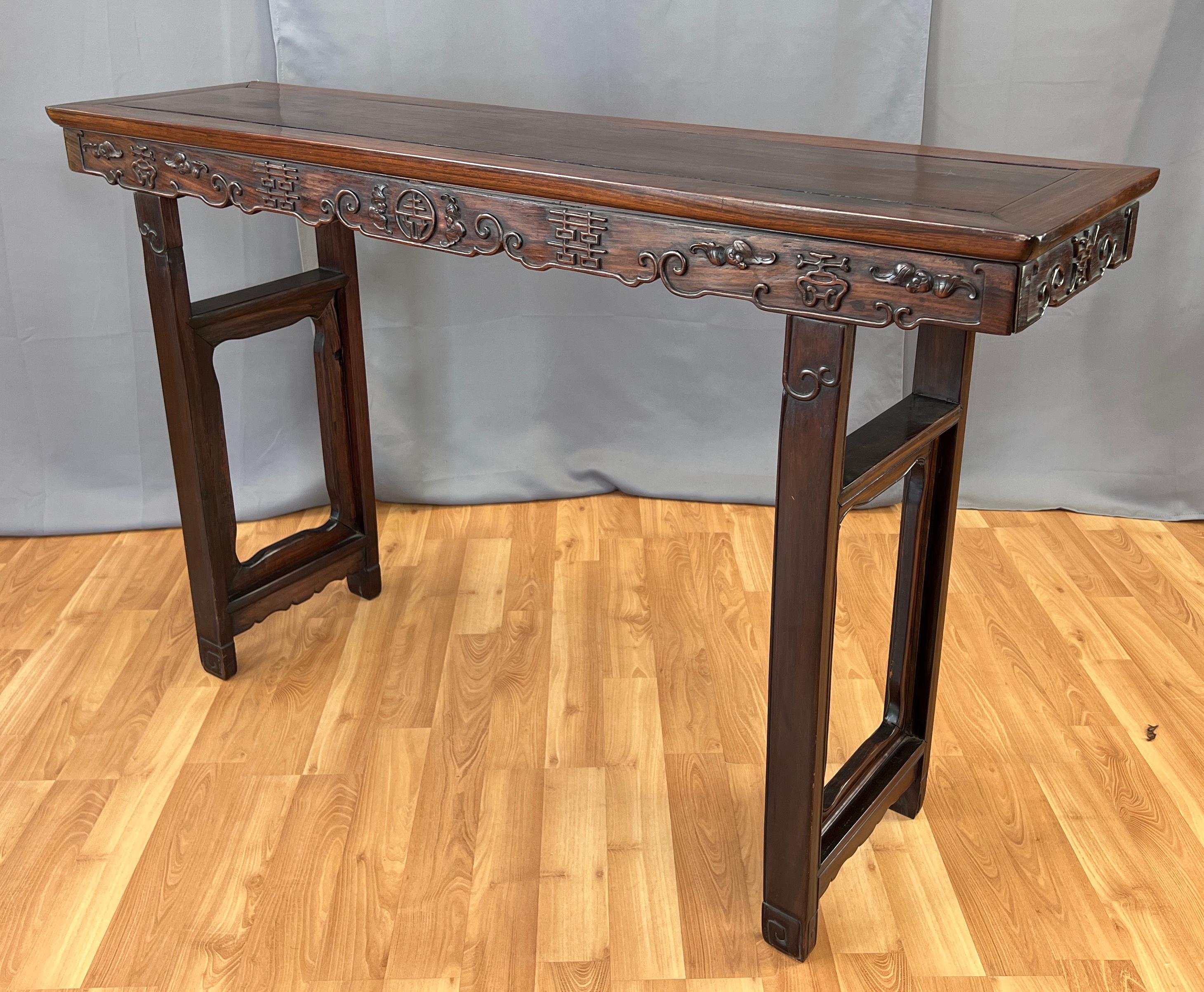 Offered here is a wonderful wooden Chinese Alter table, from the mid 20th century.
Carved on all sides of it's apron, flowers/plants, symbols and words, with some light carving on it's legs. Legs have two cross braces each, and between the legs and