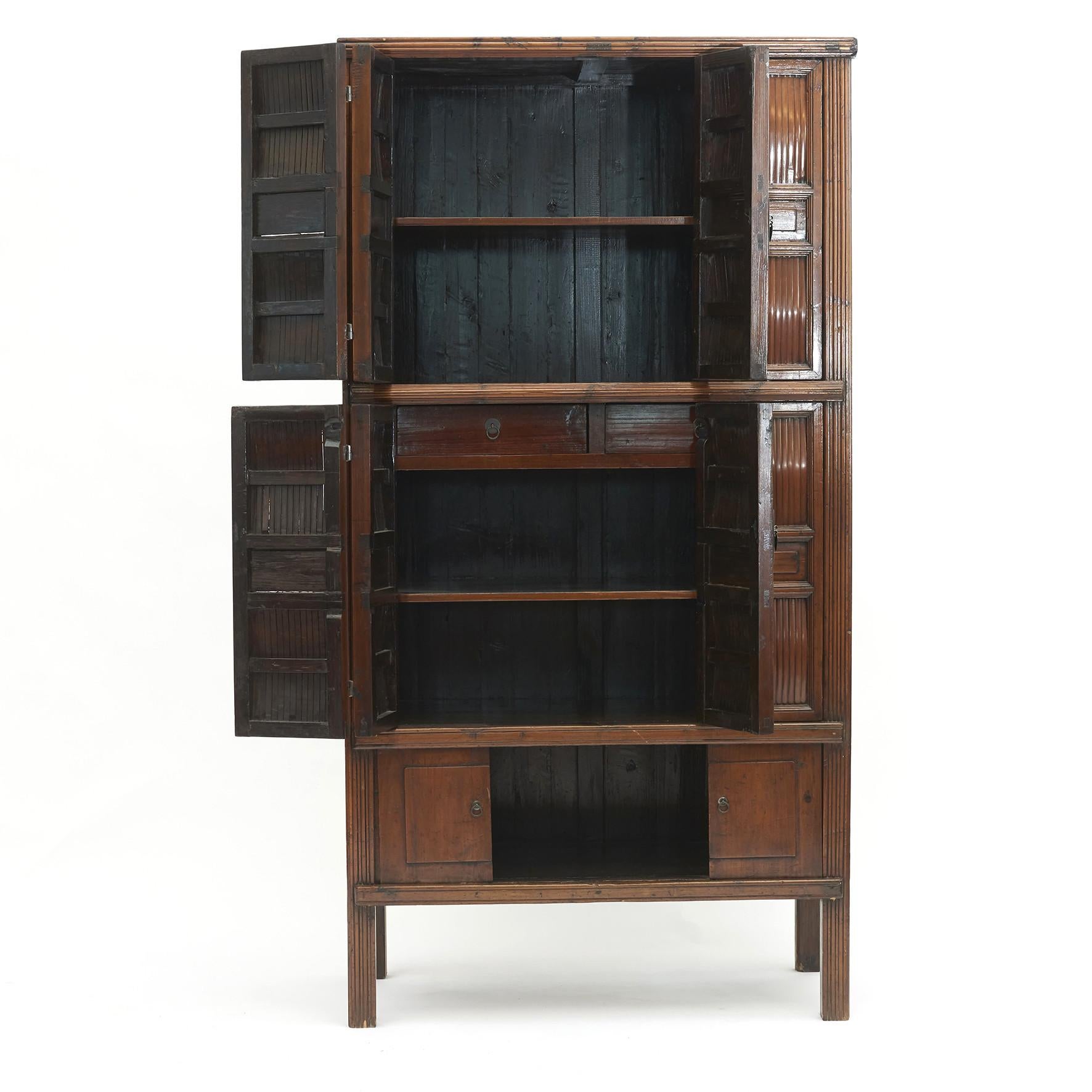 Chinese Qing dynasty Kitchen cabinet.
A Chinese Qing dynasty period kitchen cabinet from Zhejiang Province, 1840-1860.
Cypress wood with bamboo fillings in the doors.

This Chinese cabinet features two bi-fold doors that opens to reveal two