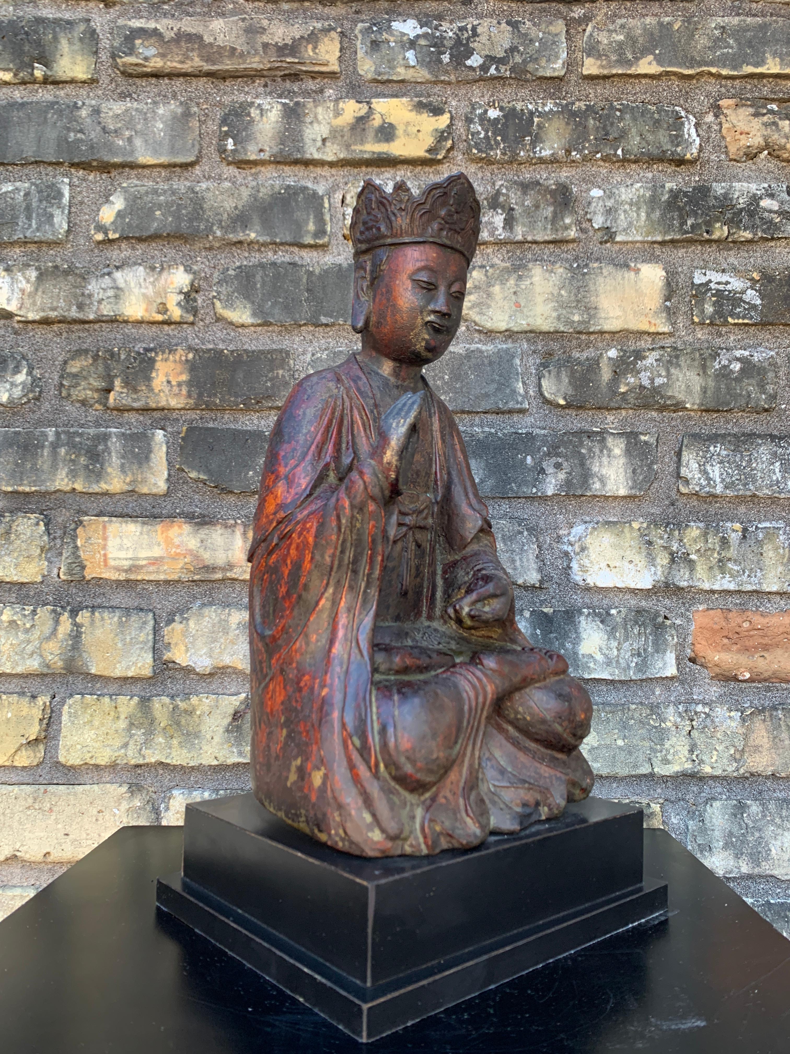 Eine geschnitzte und lackierte Holzfigur von Guanyin aus der frühen Qing-Dynastie, Südchina, 17./18. Jahrhundert.

Guanyin, der Bodhisattva des Mitgefühls und der Barmherzigkeit, wird in Dhyanasana sitzend dargestellt, eine Hand in Viktara Mudra