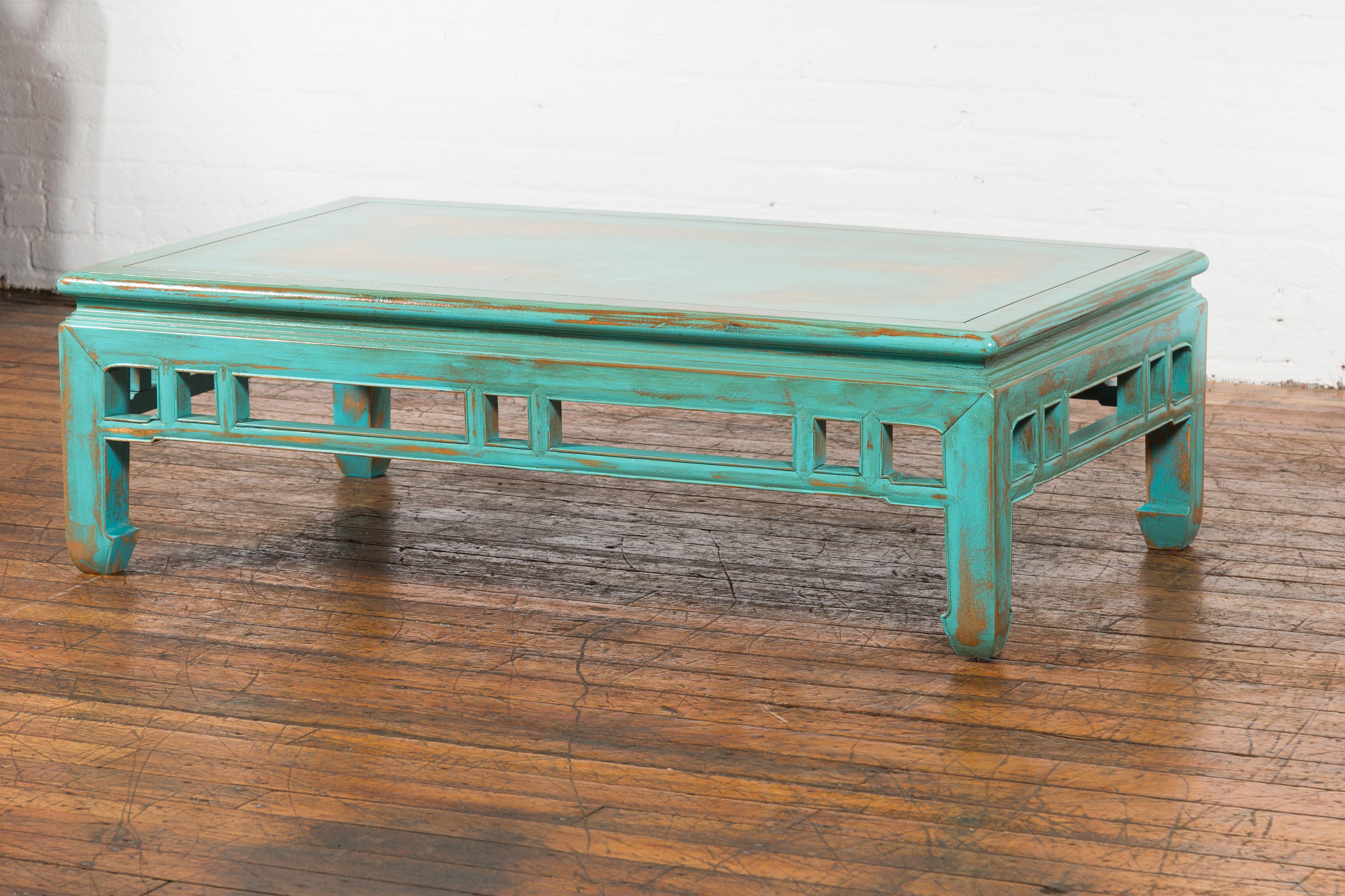 A Chinese Qing Dynasty period low Kang table from the 19th century, with open apron and humpback stretcher, restored with custom aqua teal distressed lacquer. Created in China during the Qing Dynasty period in the 19th century, this low kang table