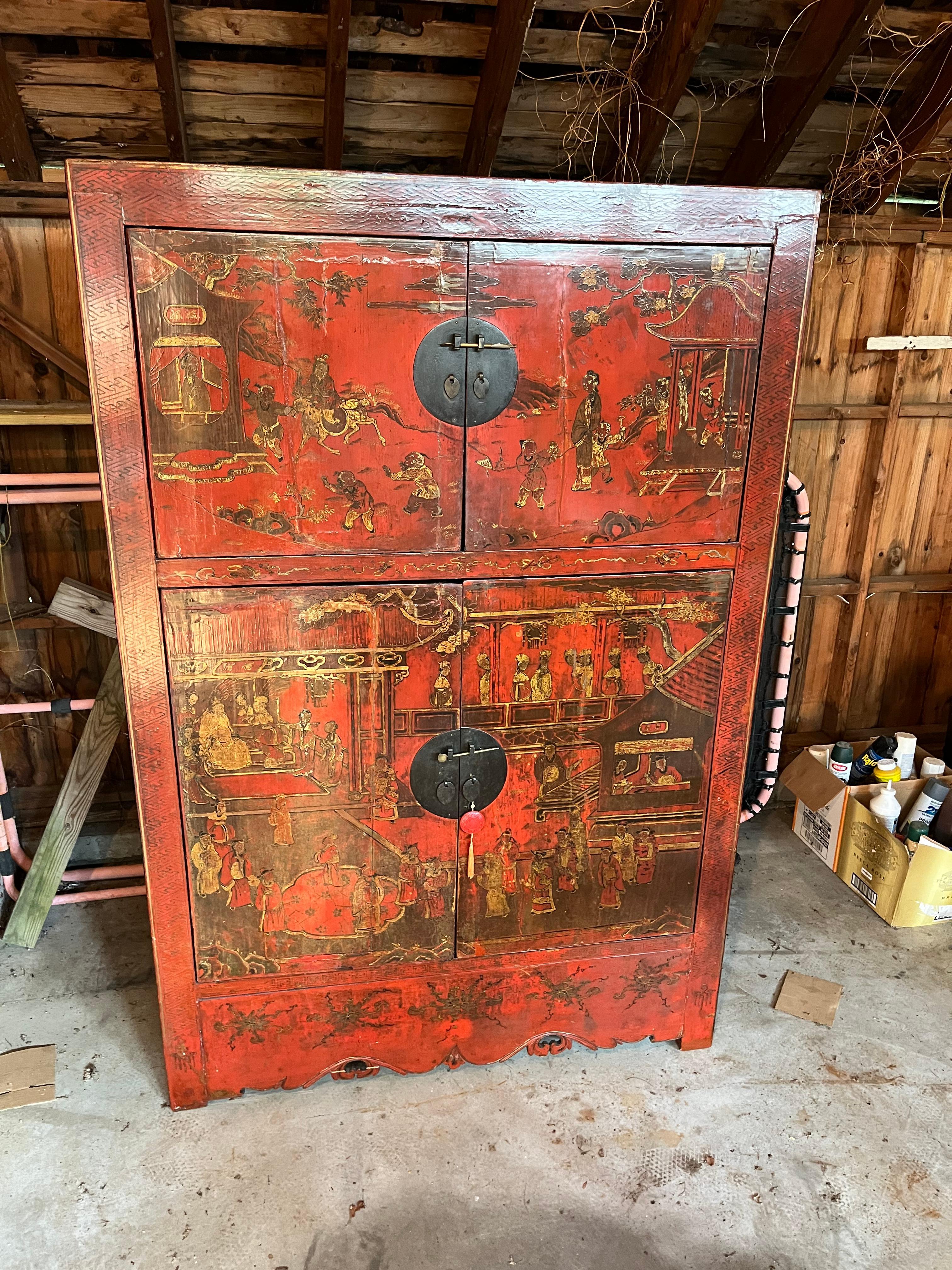 A late 18th century 4-door lacquered cabined from the Qing Dynasty, China, decorated in red lacquer with gilt and painted scenes of traditional village life of the period. The fitted interior has a shelf containing two smaller drawers. Original