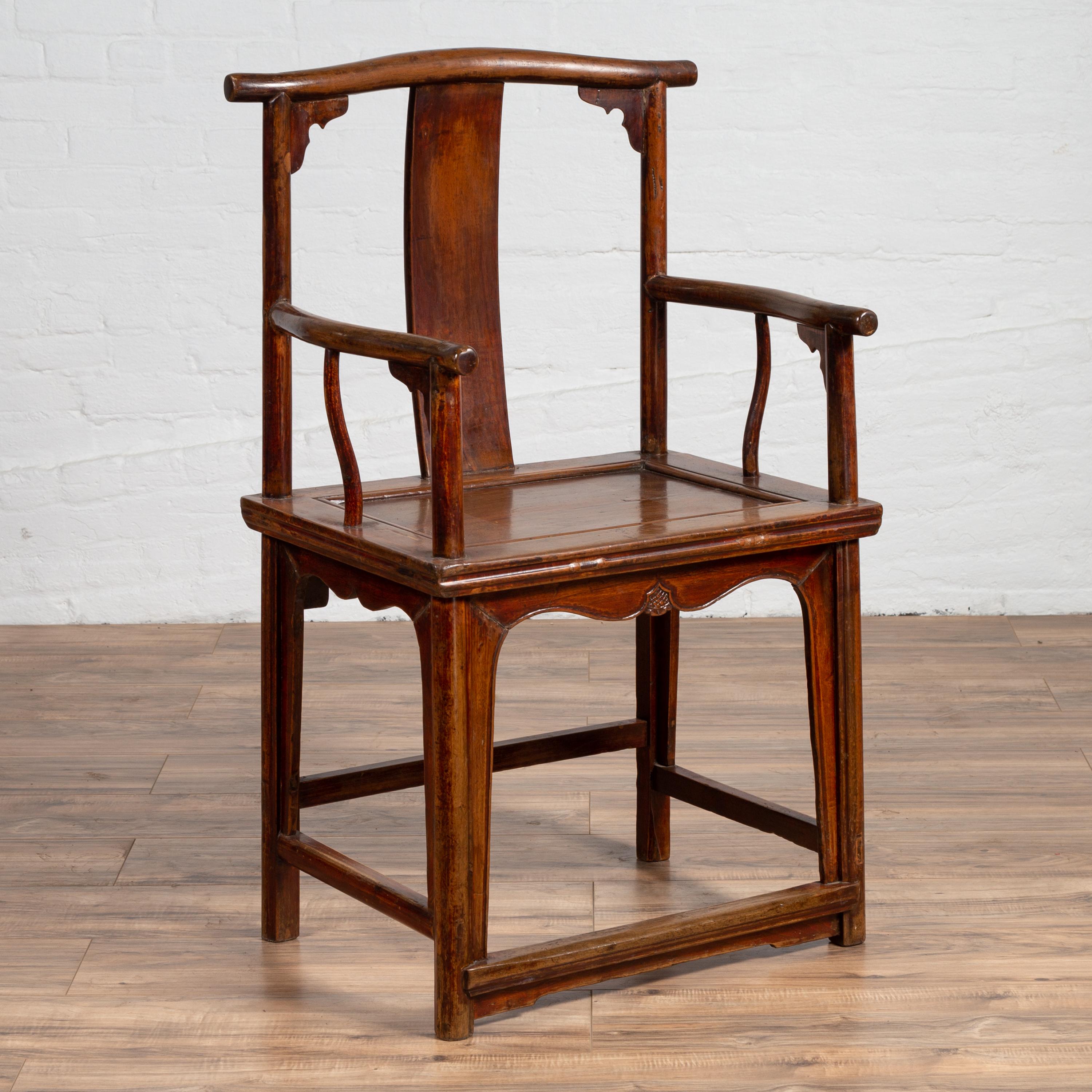 A Chinese Qing dynasty period official's lamp-hanger chair from the late 19th century with curving arms, carved spandrels and arched apron. Born in China during the last quarter of the 19th century, this Qing dynasty wooden chair features a