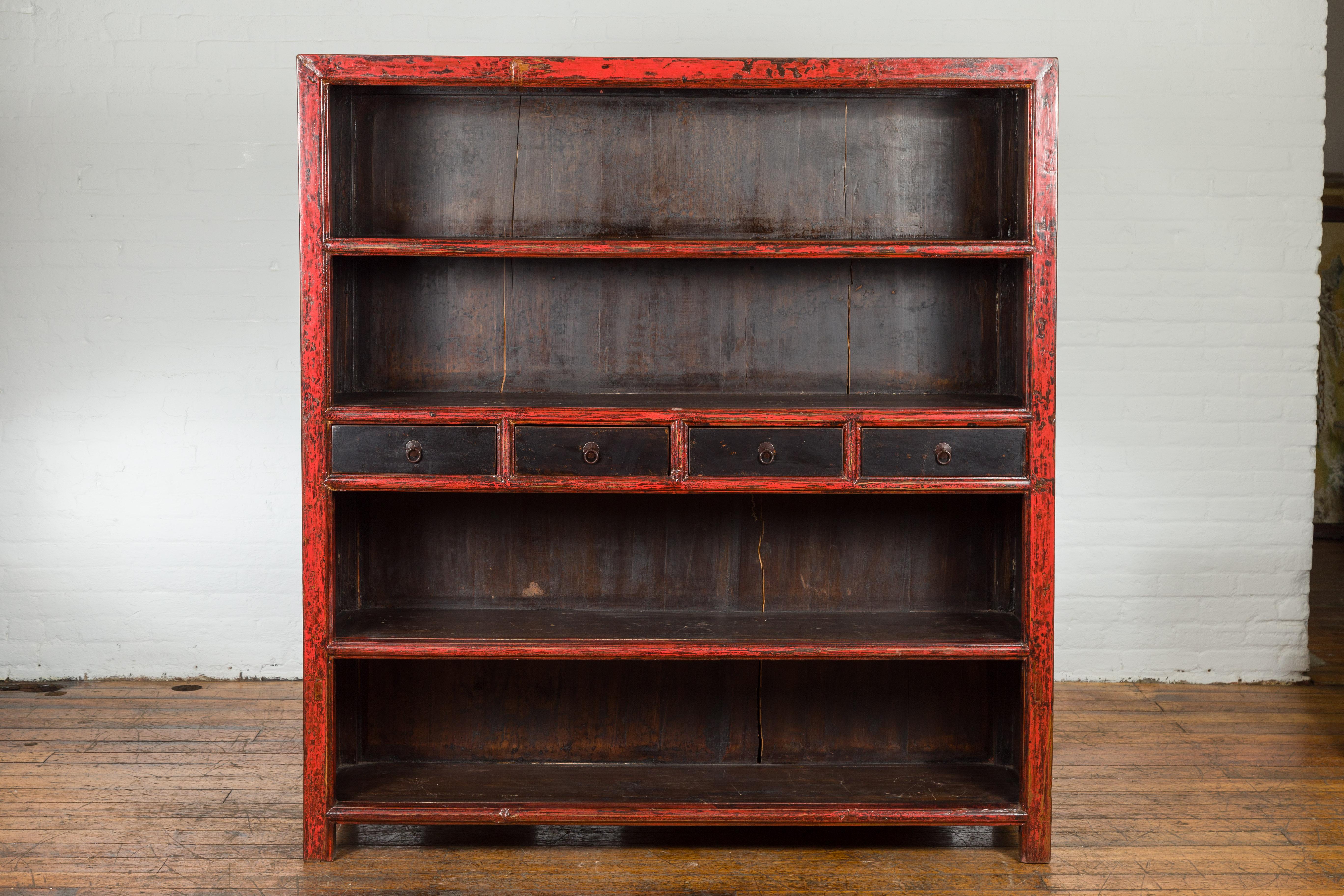 A Chinese Qing Dynasty period large bookcase from the 19th century with red and dark brown lacquer. Immerse yourself in the vibrant allure of traditional Chinese craftsmanship with this 19th-century Qing Dynasty bookcase. Crafted with precision and