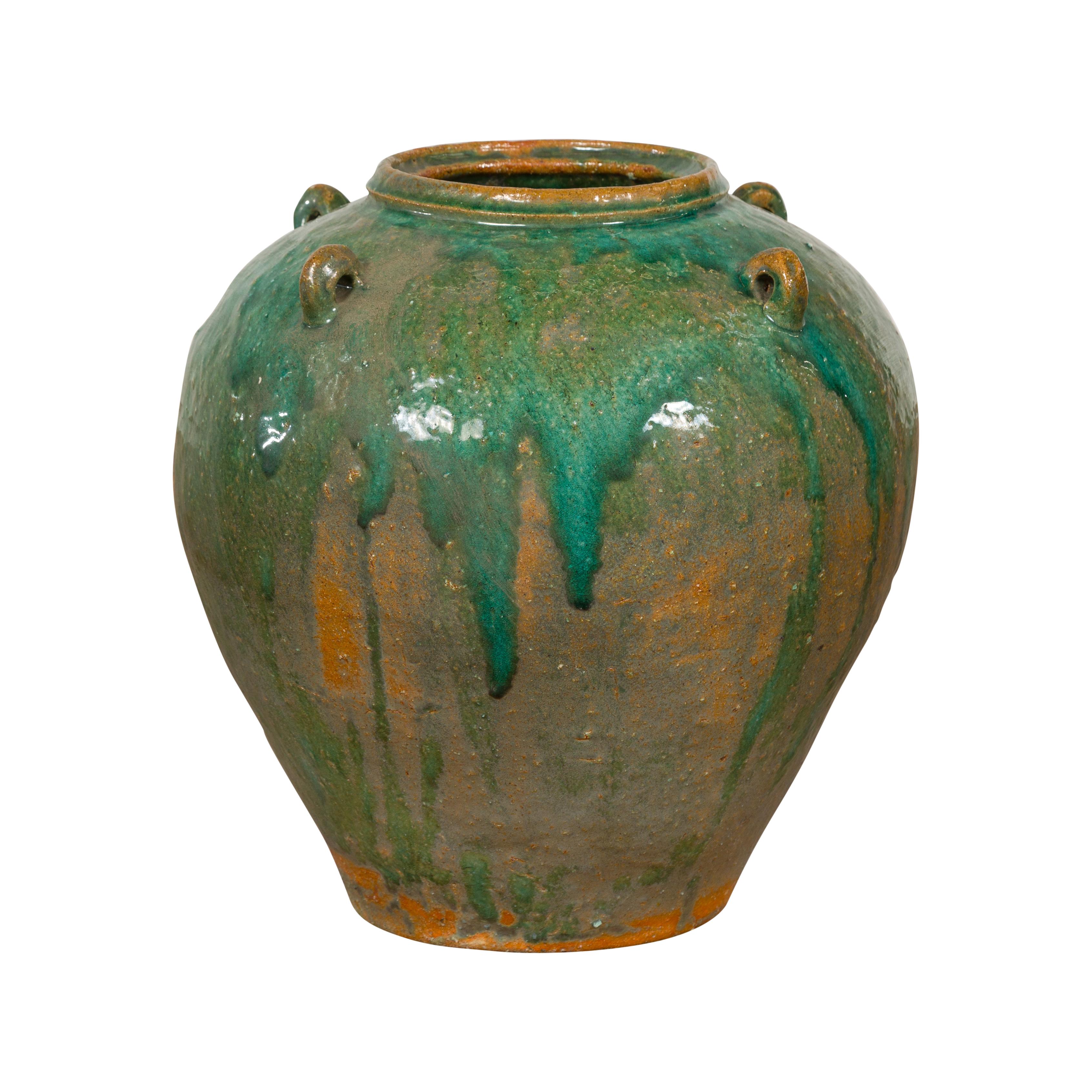 A Chinese Qing Dynasty period green glaze jar from the 19th century with dripping effects and petite loop handles. Discover the captivating allure of this Chinese Qing Dynasty period green glaze jar from the 19th century. Hand crafted, this piece