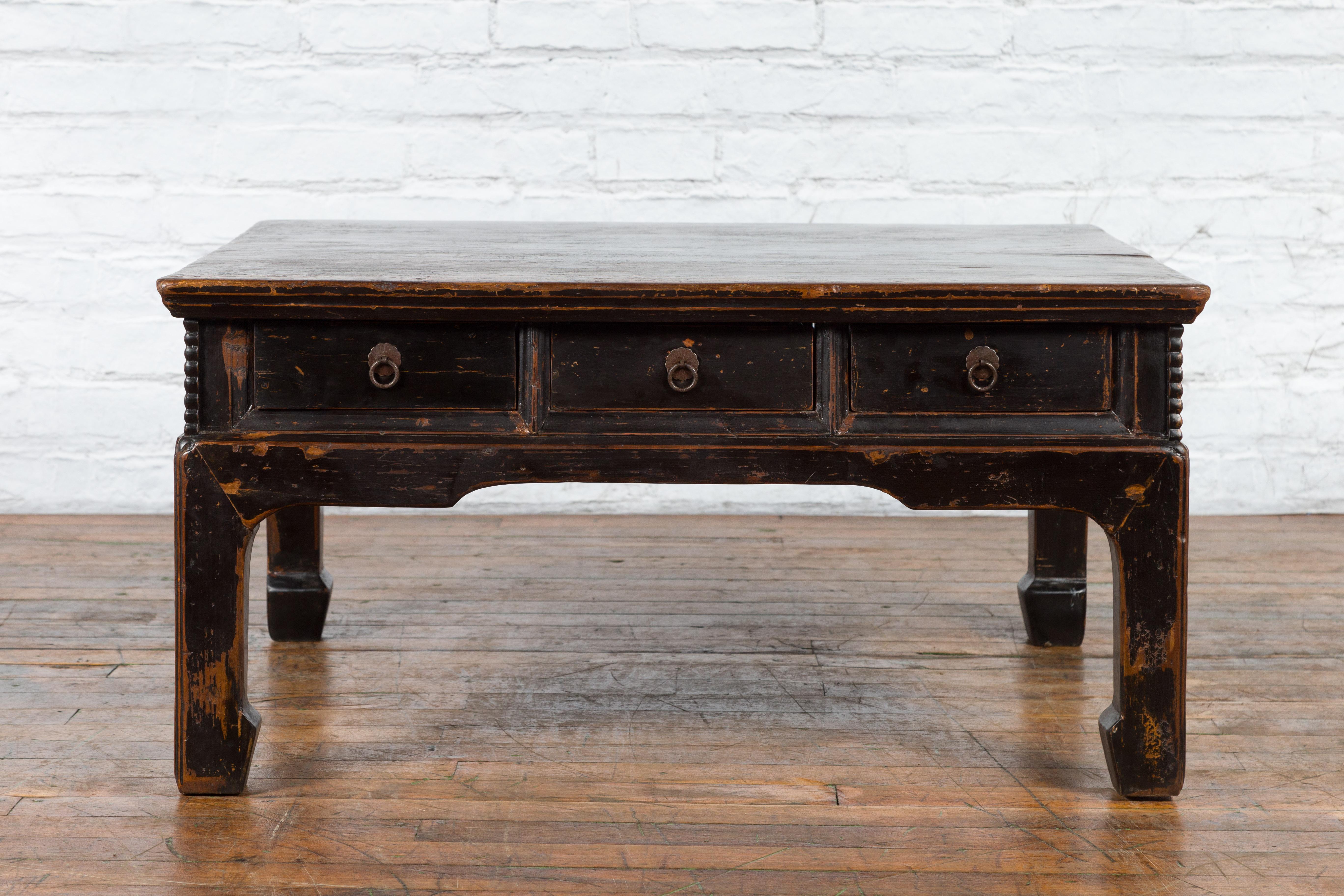An Chinese Qing Dynasty period low coffee table from the 19th century with original rubbed patina and six drawers. Created in China during the Qing Dynasty (1636–1912), this low table, which could nowadays be used as a coffee table (the Chinese