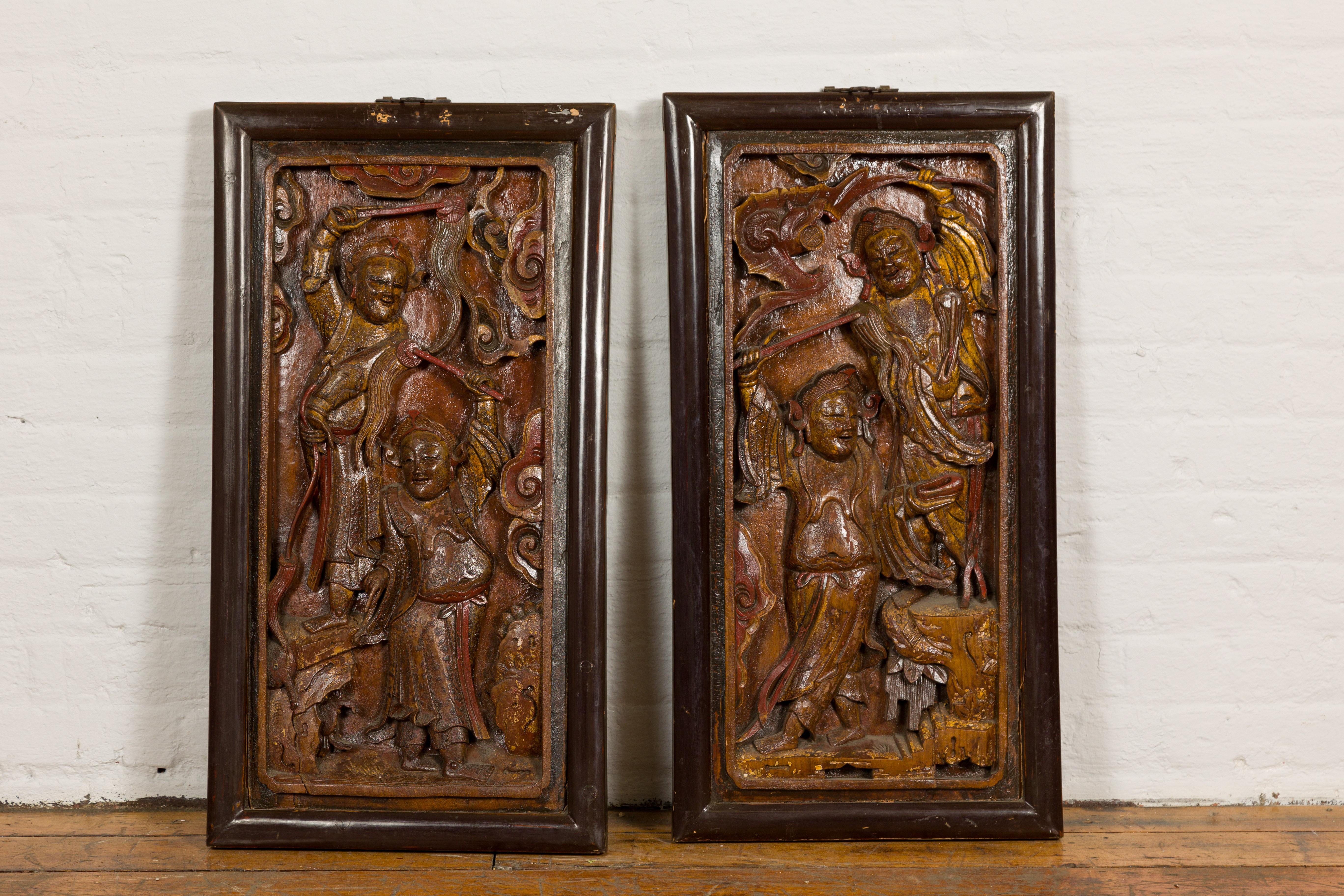 A pair of Chinese Qing Dynasty period hand-carved and lacquered puppet show signs from the 19th century each depicting two characters. Travel back to the vibrant world of 19th century Chinese theater with this pair of Qing Dynasty hand-carved puppet