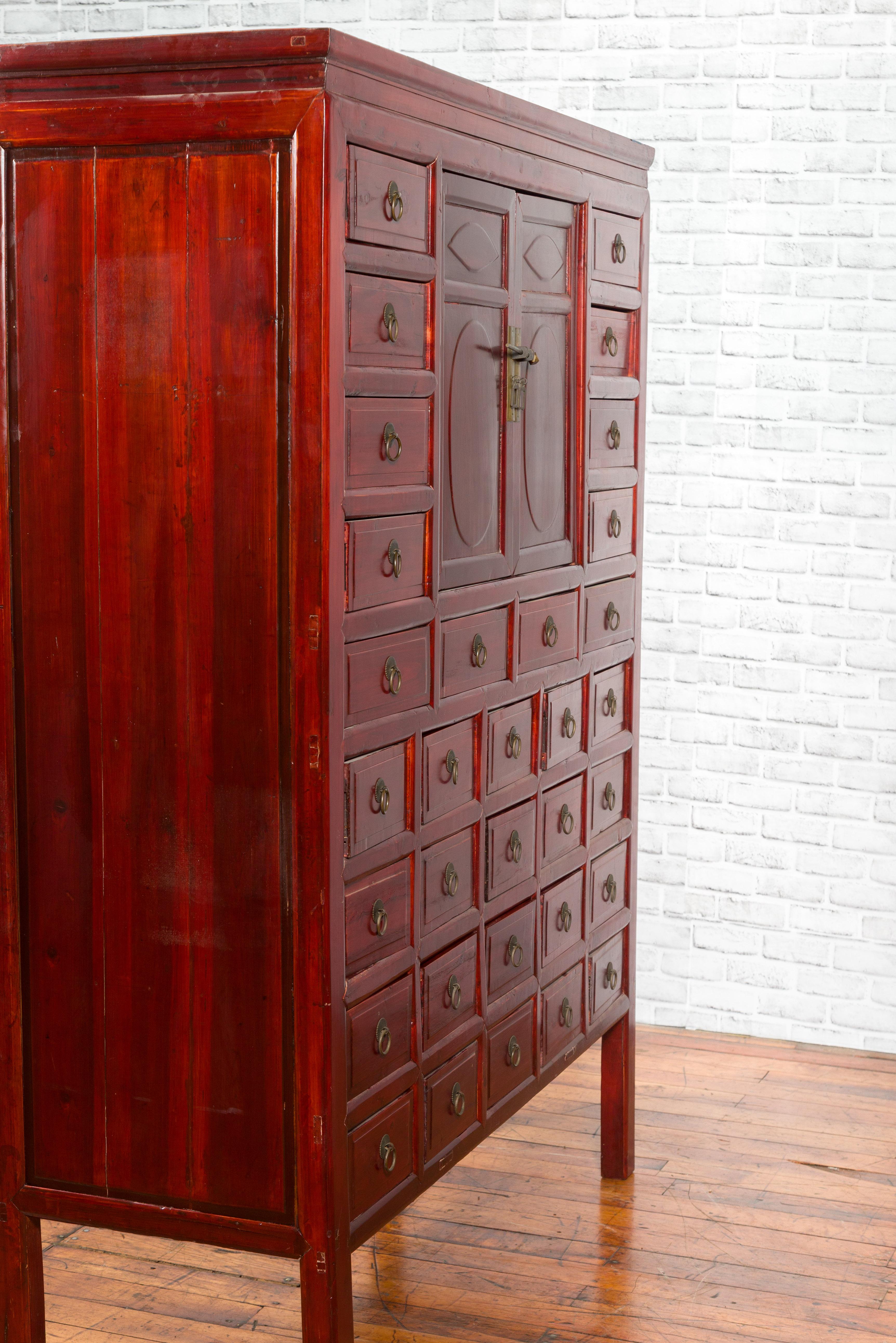 Armoire d'apothicaire chinoise des années 1930 en laque rouge avec 32 tiroirs et panneaux sculptés en vente 7