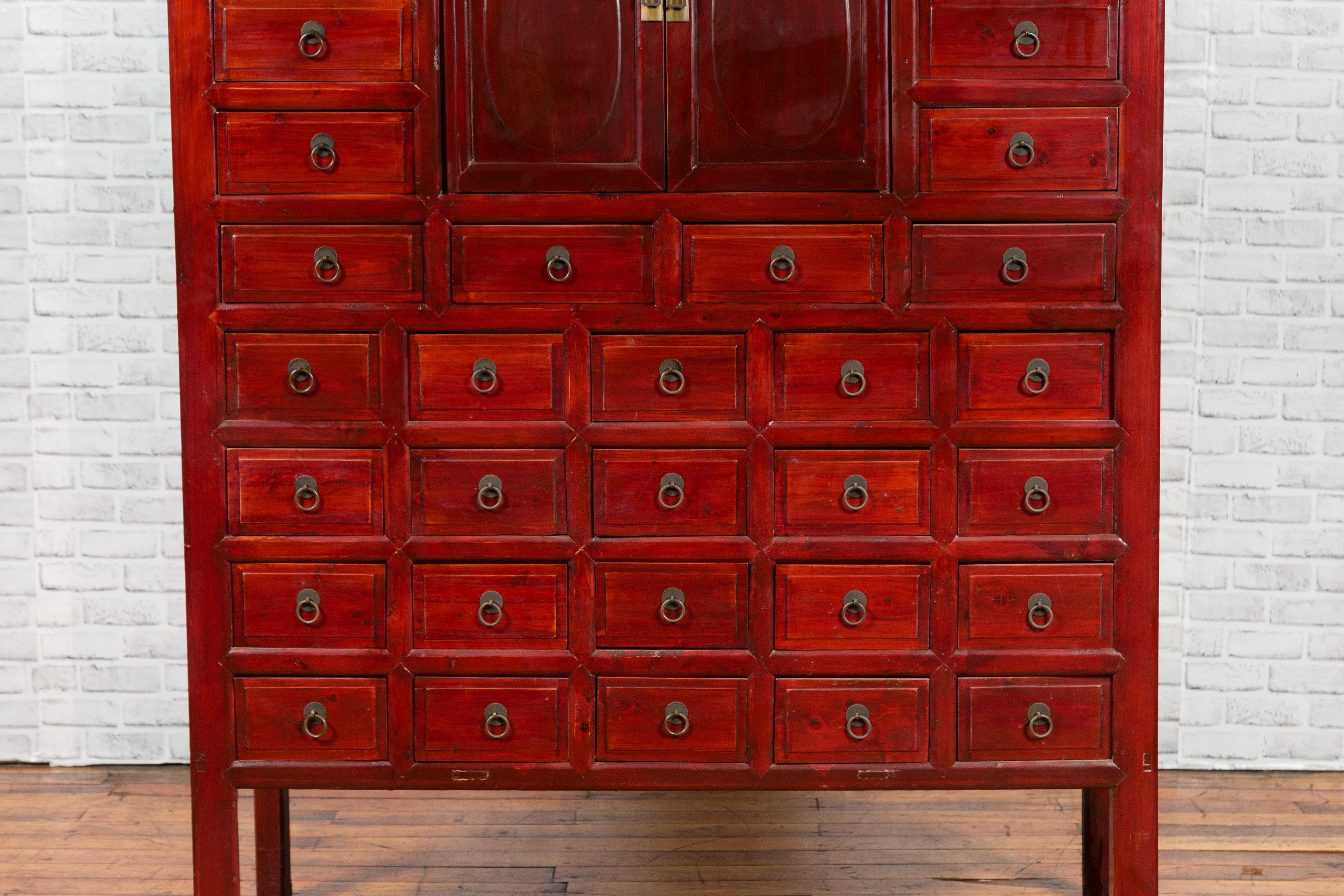 20ième siècle Armoire d'apothicaire chinoise des années 1930 en laque rouge avec 32 tiroirs et panneaux sculptés en vente