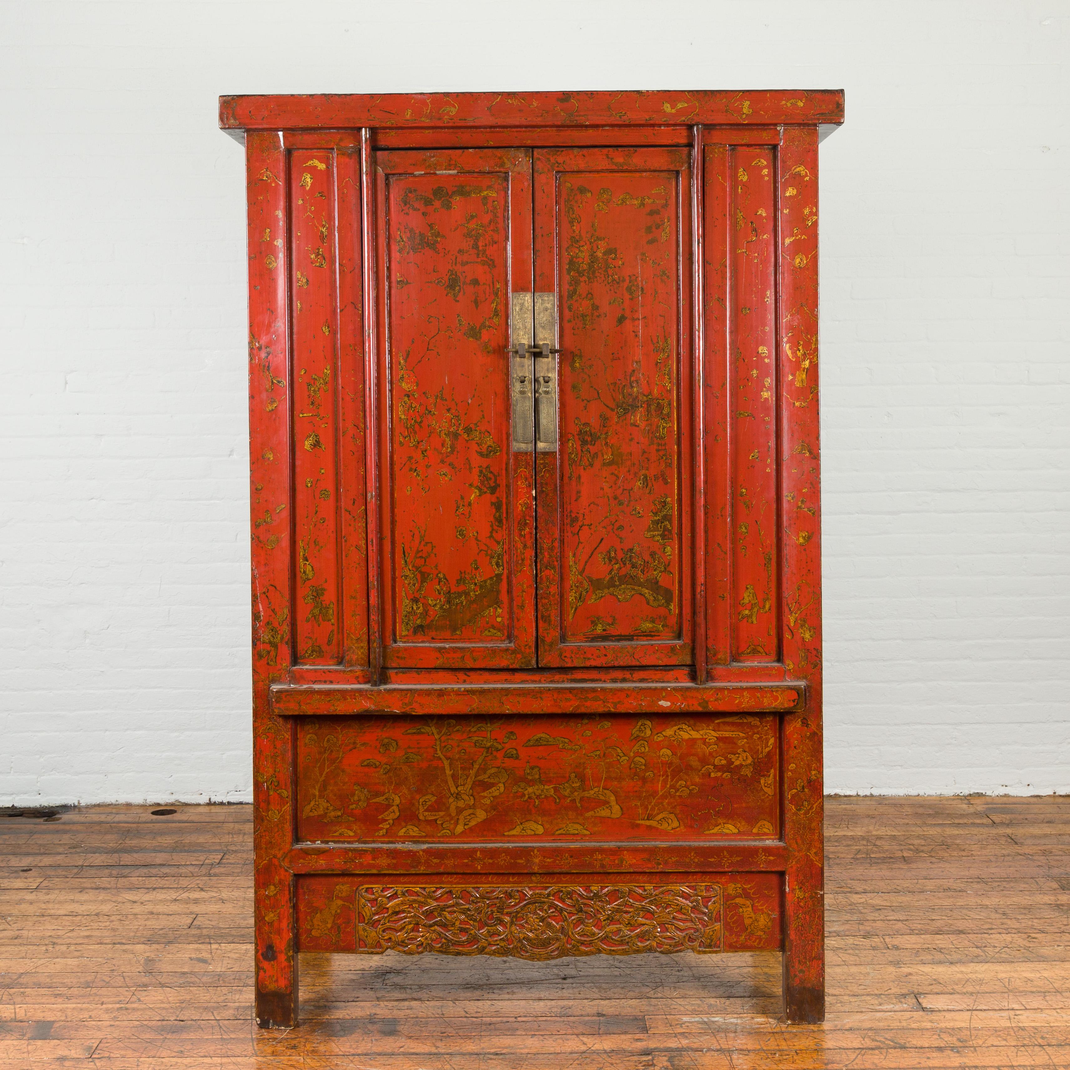A Chinese Qing Dynasty period cabinet from the 19th century, with original red lacquer, hand-painted golden scenes and carved apron. Created in China during the Qing Dynasty, this red lacquered cabinet features two doors fitted with ornate bronze