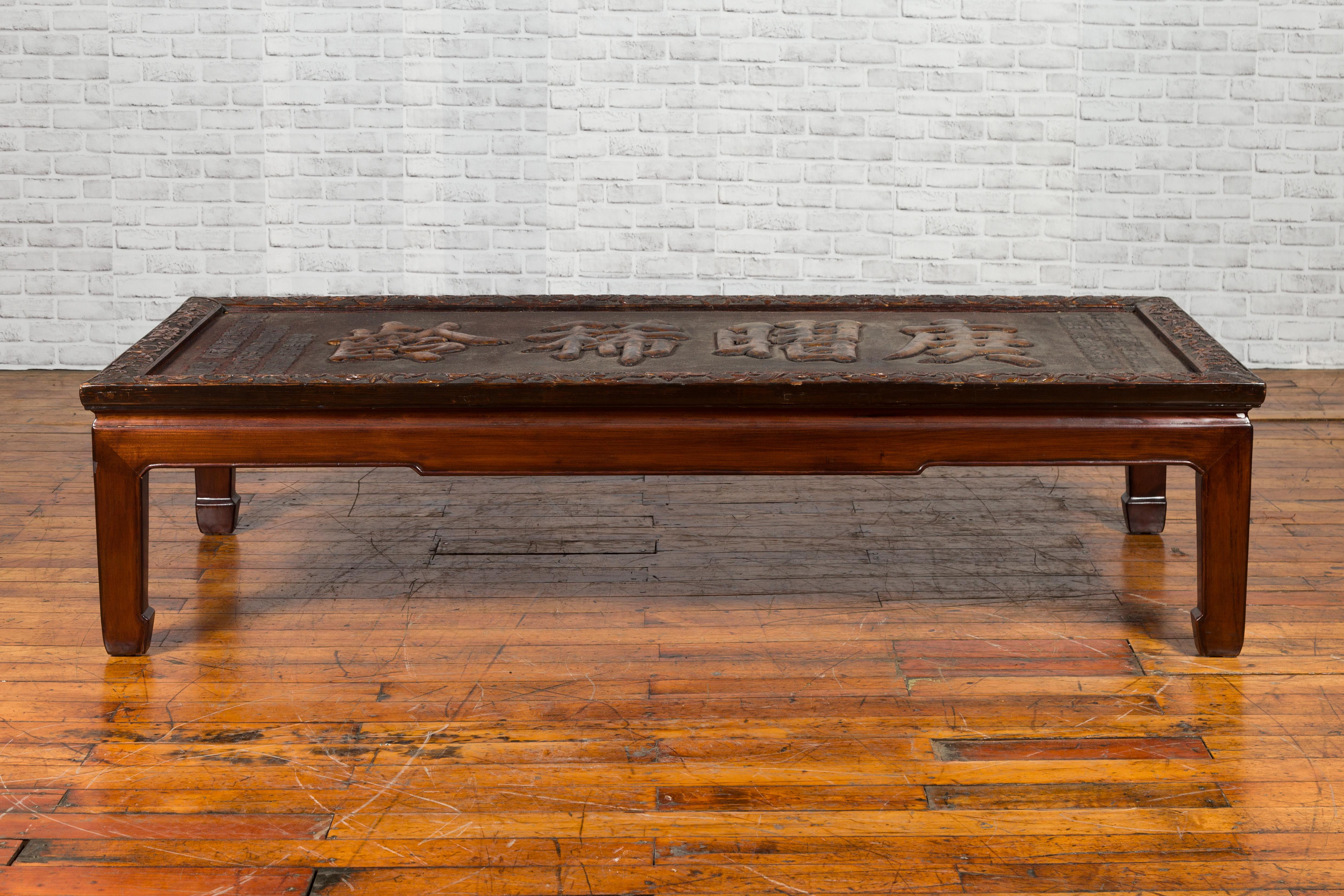 A Chinese Qing dynasty shop sign from the 19th century with gilded calligraphy, made into a coffee table. Created in China during the Qing dynasty, this rectangular shop sign, adorned with four large raised gilded calligraphy characters flanked with