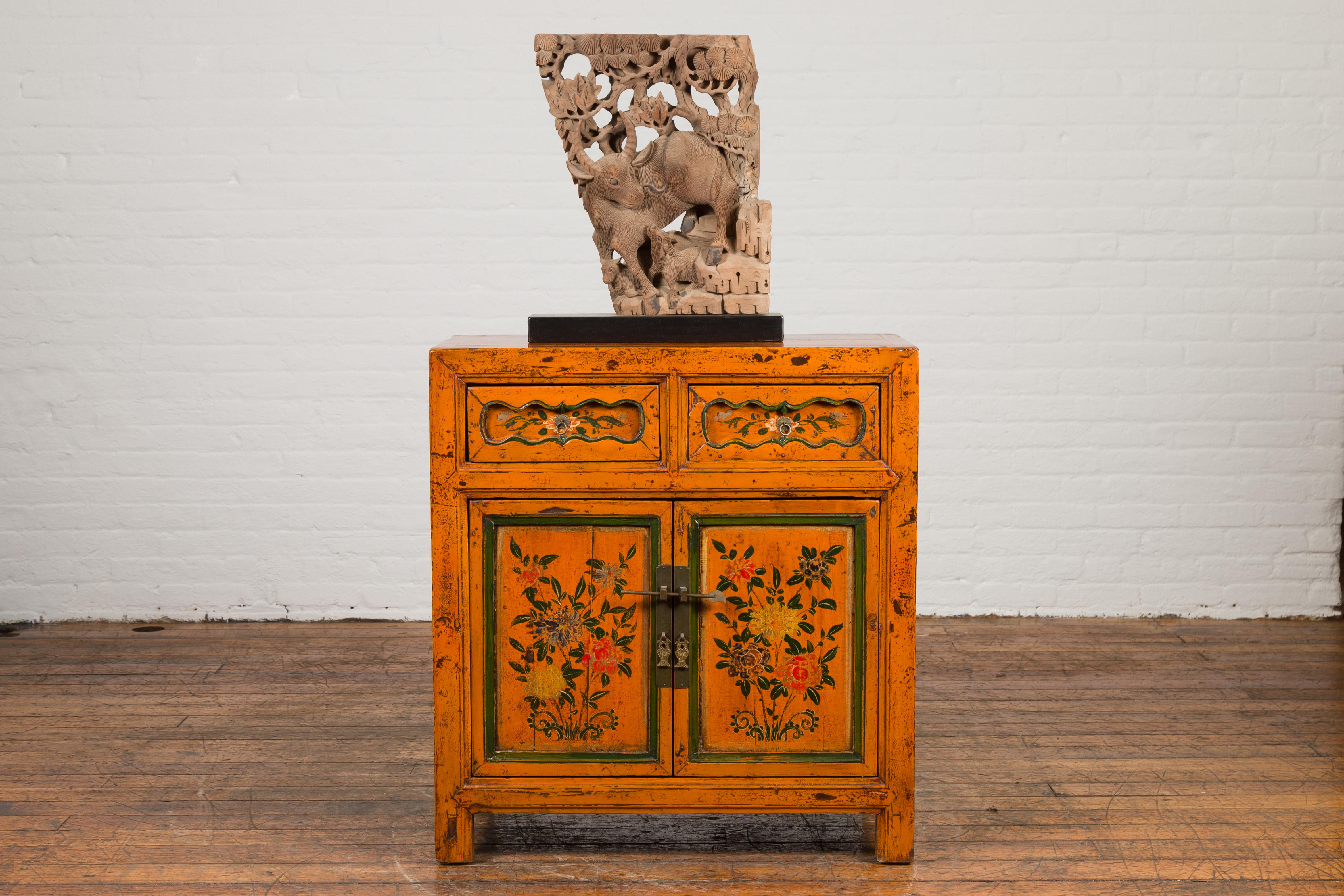 A Chinese Qing dynasty period small Gansu cabinet from the 19th century, with Tibetan style hand-painted floral decor. Created in the north central province of Gansu during the 19th century, this rectangular cabinet features two drawers above two