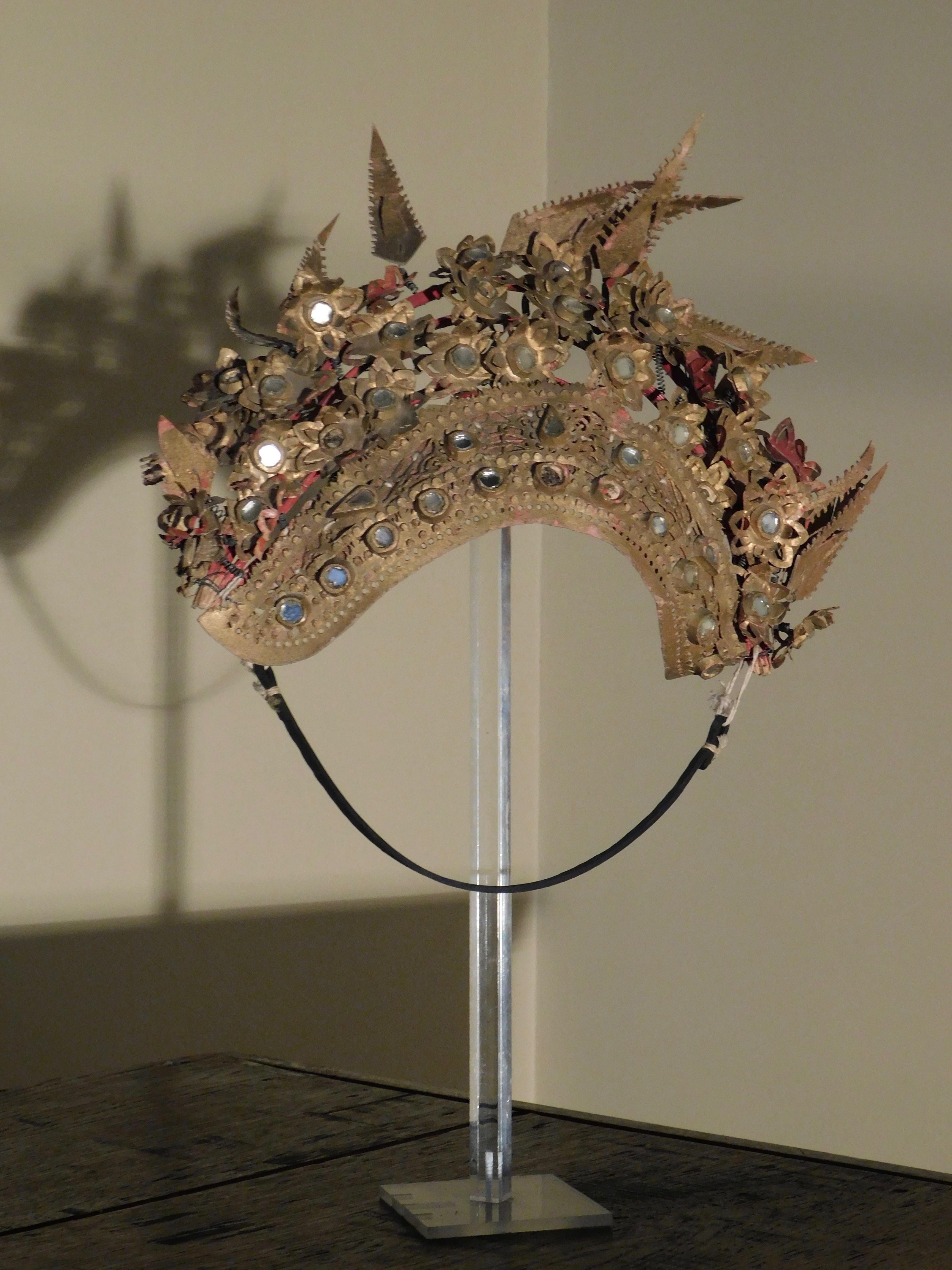 Qing dynasty Provincial Chinese wedding tiara, circa 1900.
The tiara is constructed with a painted wood frame with handwoven textile padding and decorated with delicately handcut leather. The leather is gold painted and mounted with glass mirrors.