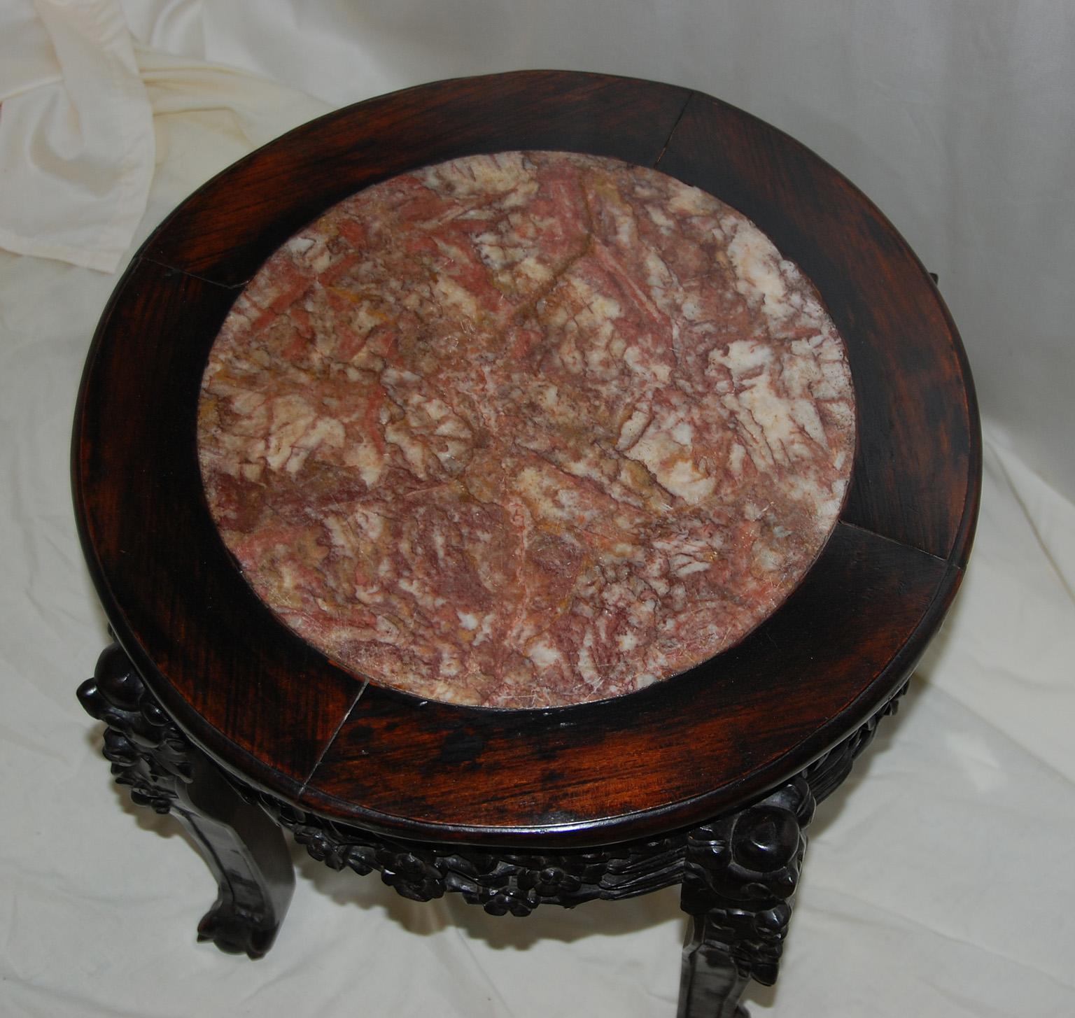 Chinese Qing dynasty rosewood carved stool with rose marble inlaid seat. The intricate carving contrasts beautifully with the round rose marble inlay of the seat. This stool can easily be used as extra seating, a pedestal for a plant or piece of