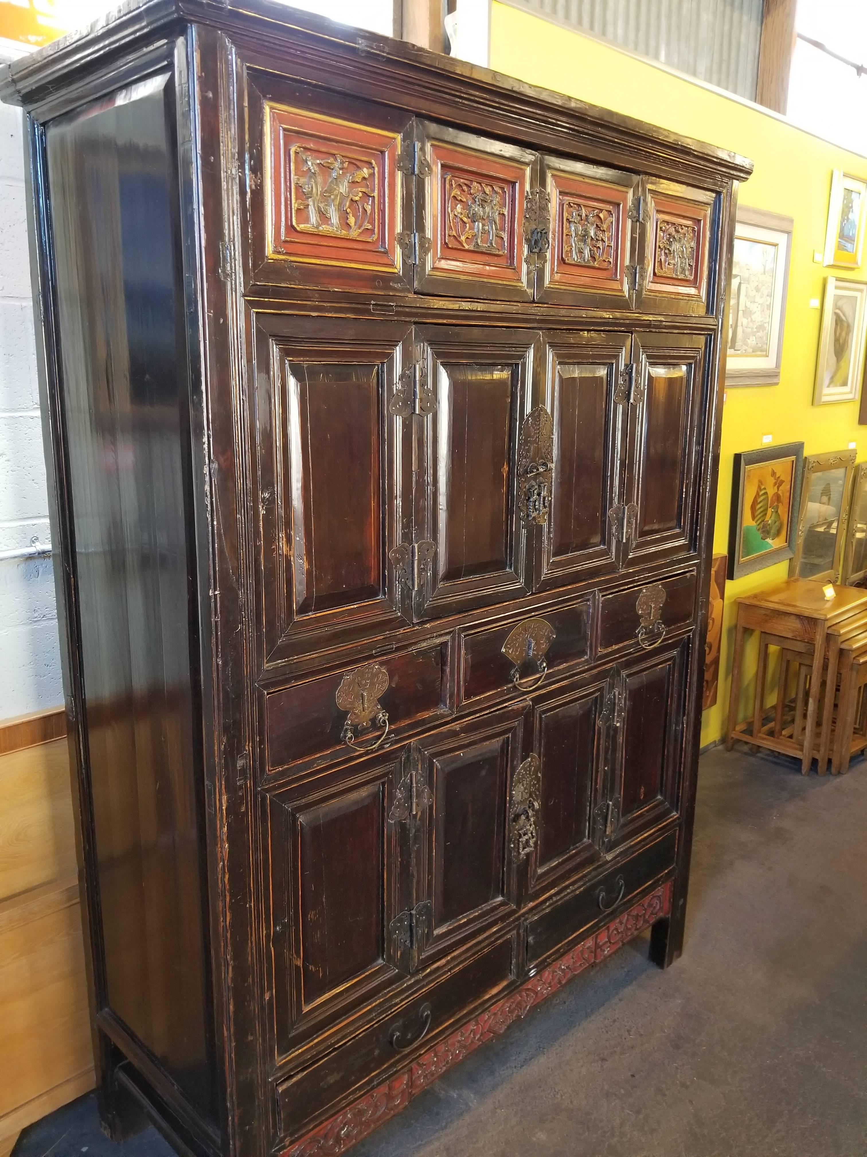 Impressive large-scale 19th century antique storage cabinet from Zhejiang, China. Ample storage with multiple cabinet doors and drawers. Handsome original metal incised hardware and red lacquer detail with figures. Mortise and tenon construction. A