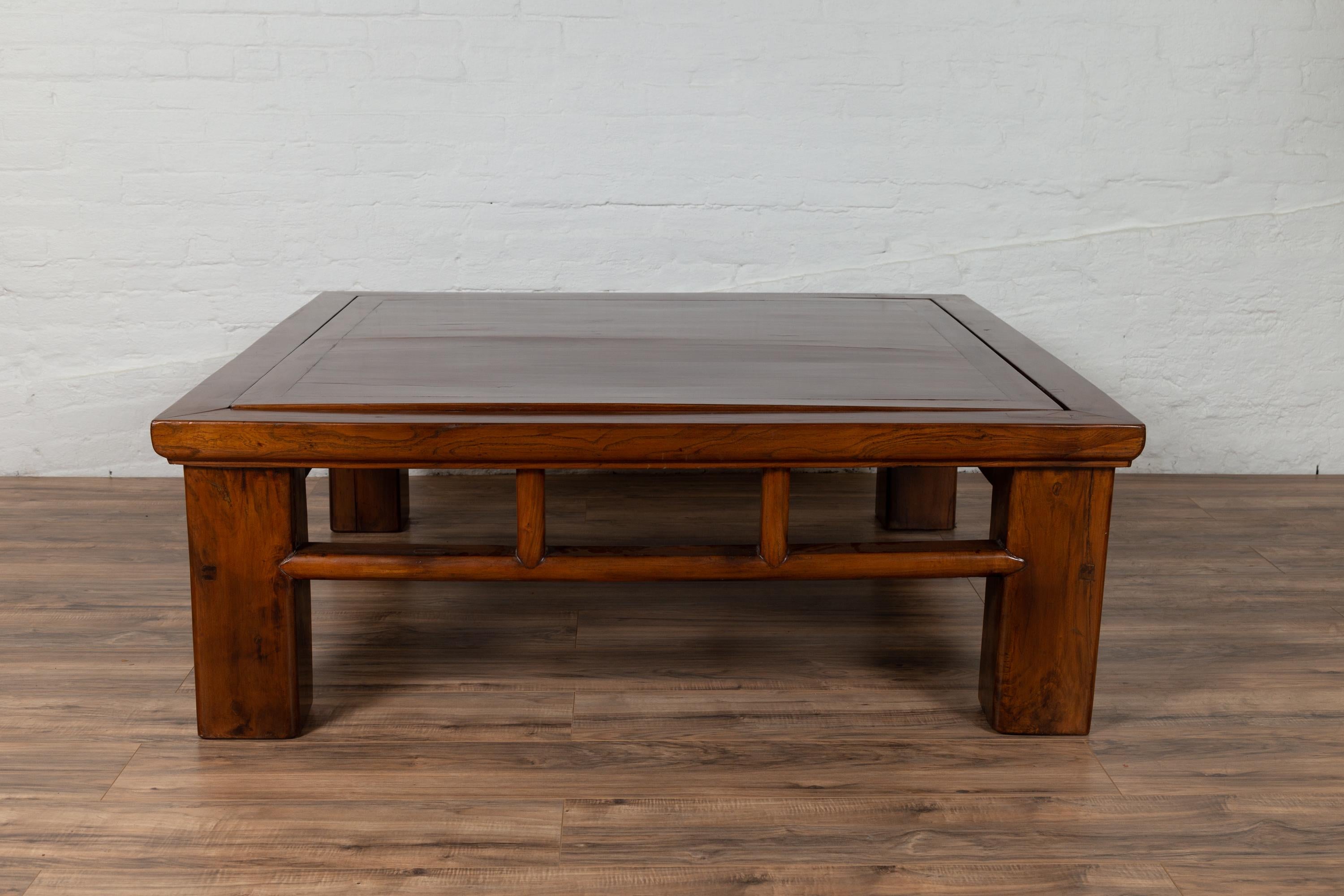 A Chinese vintage Qing dynasty style elmwood coffee table from the mid-20th century, with reversible top, pierced apron and pillar-shaped strut motifs. Born in China during the midcentury period, this exquisite coffee table features a square top