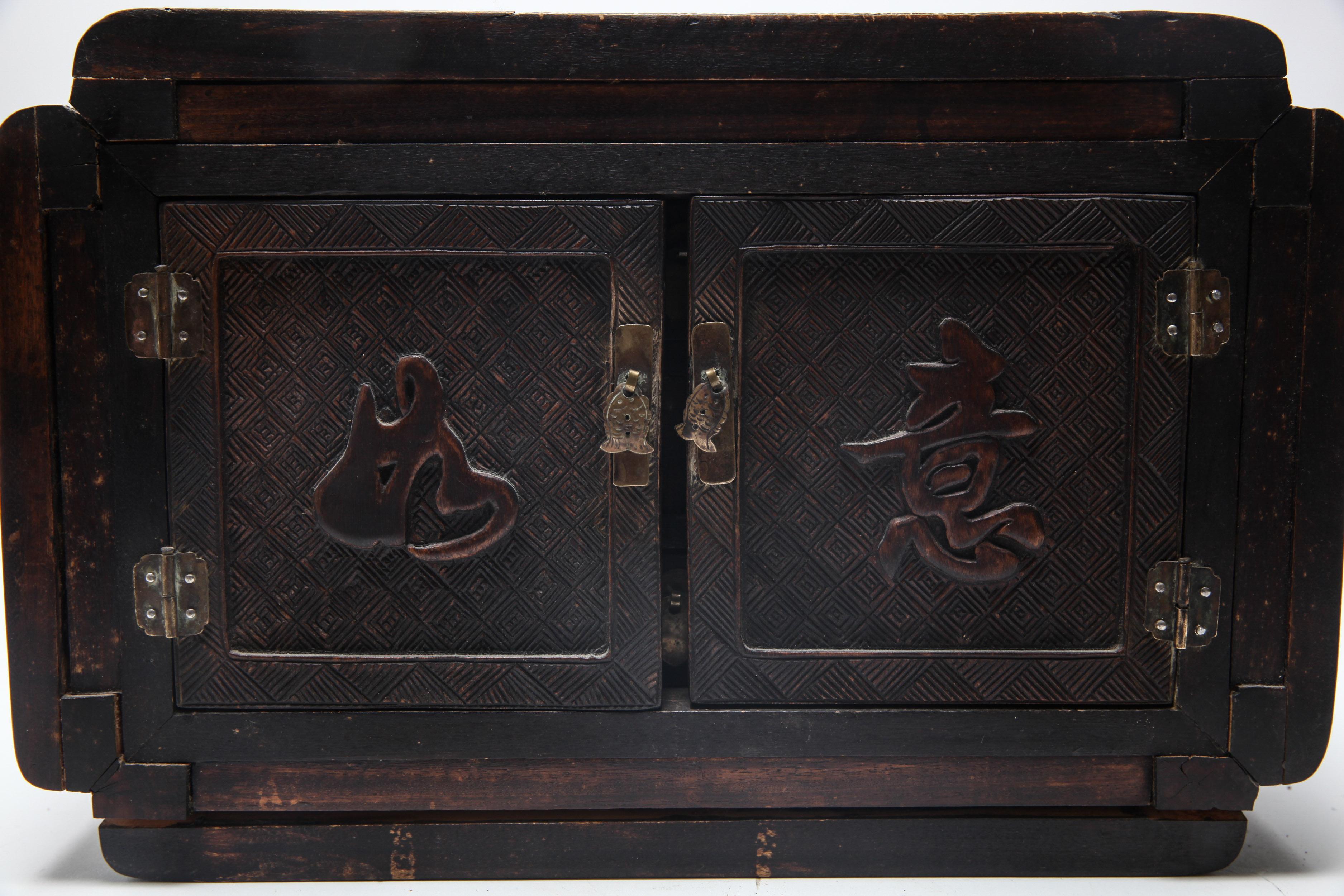 Chinese Qing Dynasty carved ironwood and wood treasure or jewelry box, with carved characters on the doors and internal drawers. The piece has an attached tag inscribed 