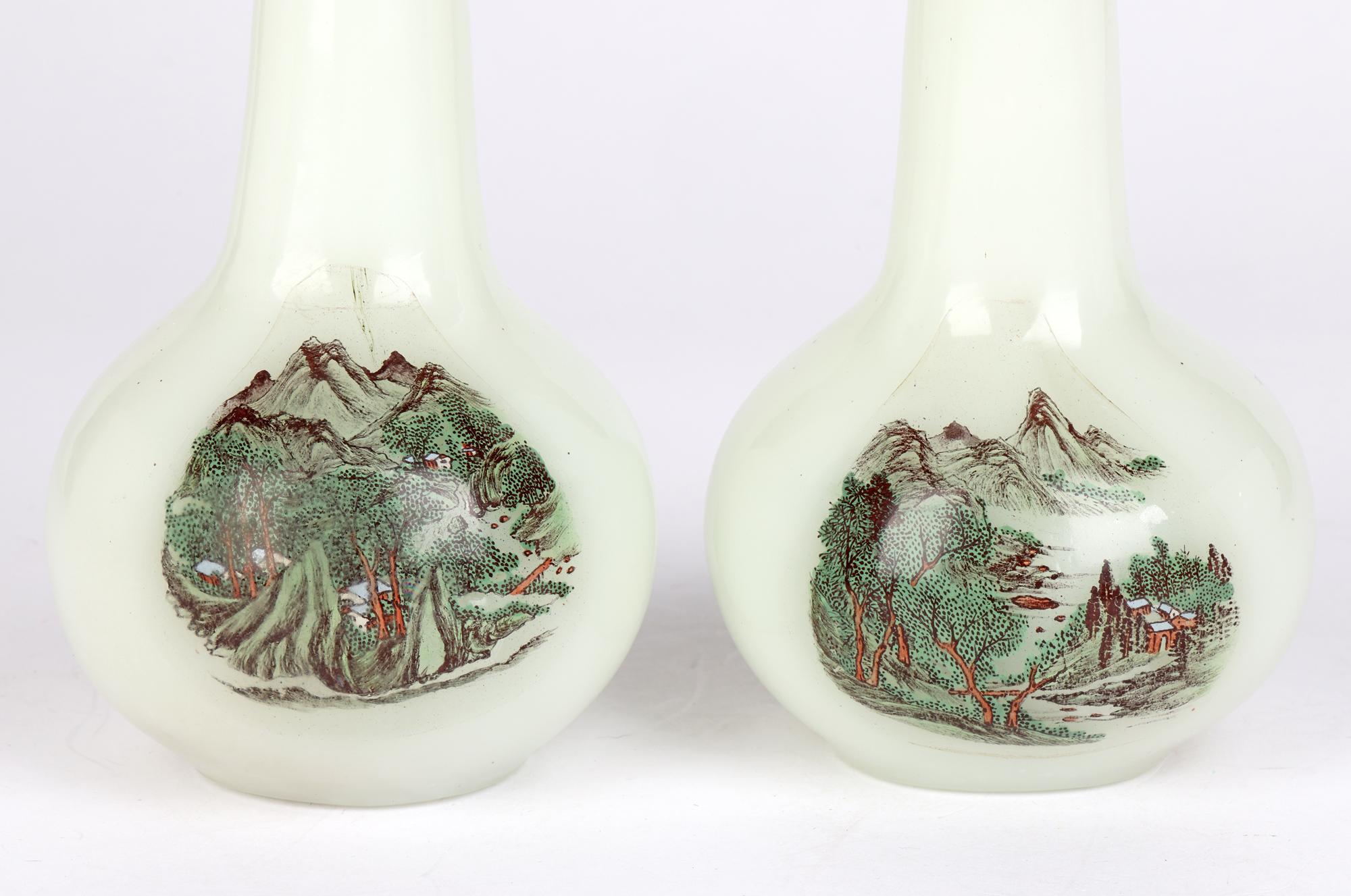 A fine and unusual pair antique Chinese Qing Peking glass vases finely hand decorated with landscape panels dating from the 19th century or possibly earlier. The vases are blown in an opaque colored glass standing on a narrow round foot and with a