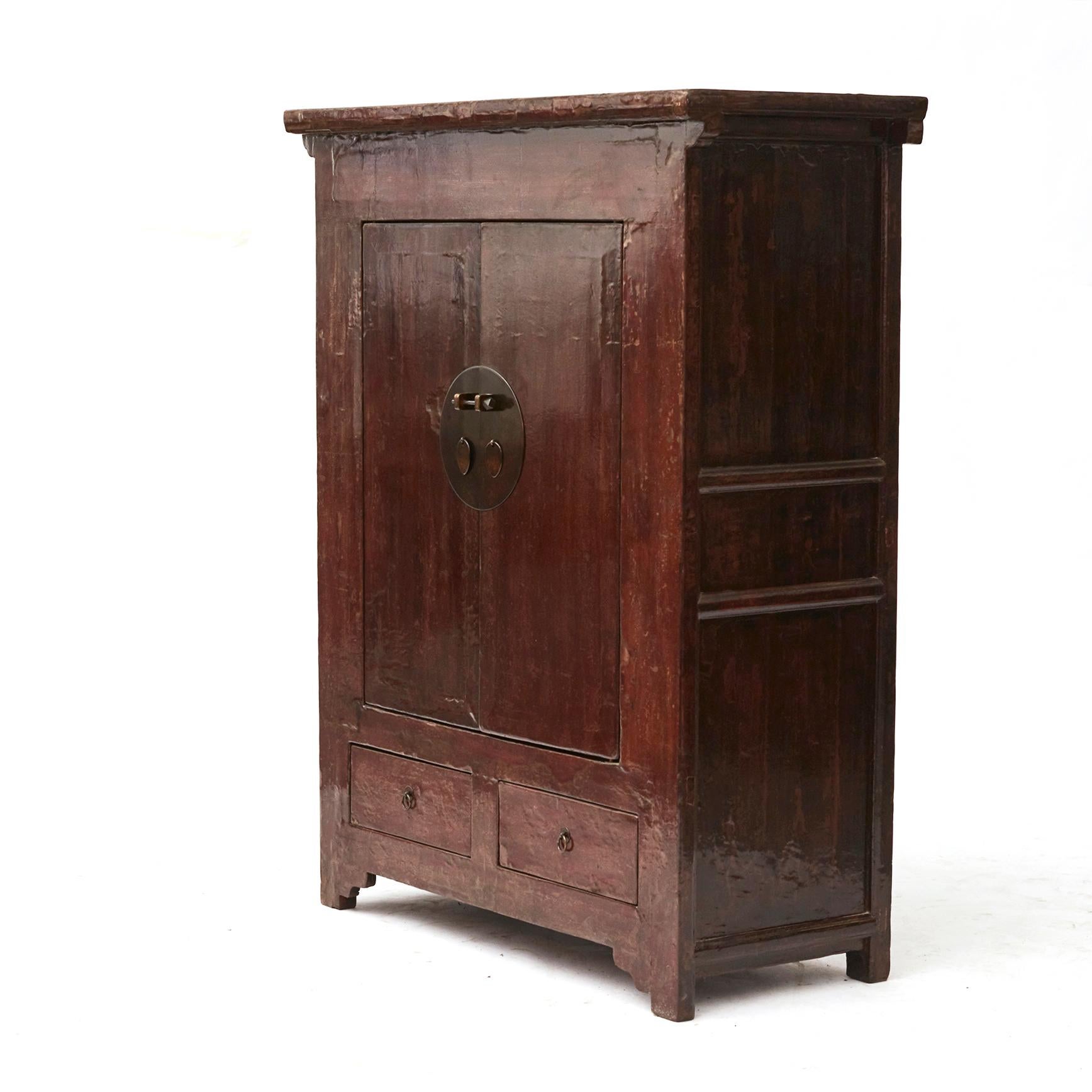 A early 19th century qing dynasty cabinet boasting a deep red patina from the Shanxi Province, circa. 1820-1830.
The façade showcases two doors fitted with a traditional round medallion lock, opening to reveal two inner shelves for storage space.