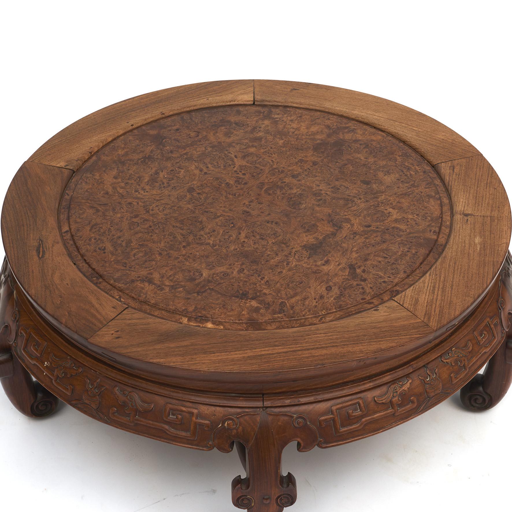 Chinese Qing style Kang table with circular paneled top over a carved apron enriched with relief dragons.
Table top with blackwood frame and root wood panel.
5 C-curved legs with stretcher terminating in scroll-form feet.
Qing style, China, circa
