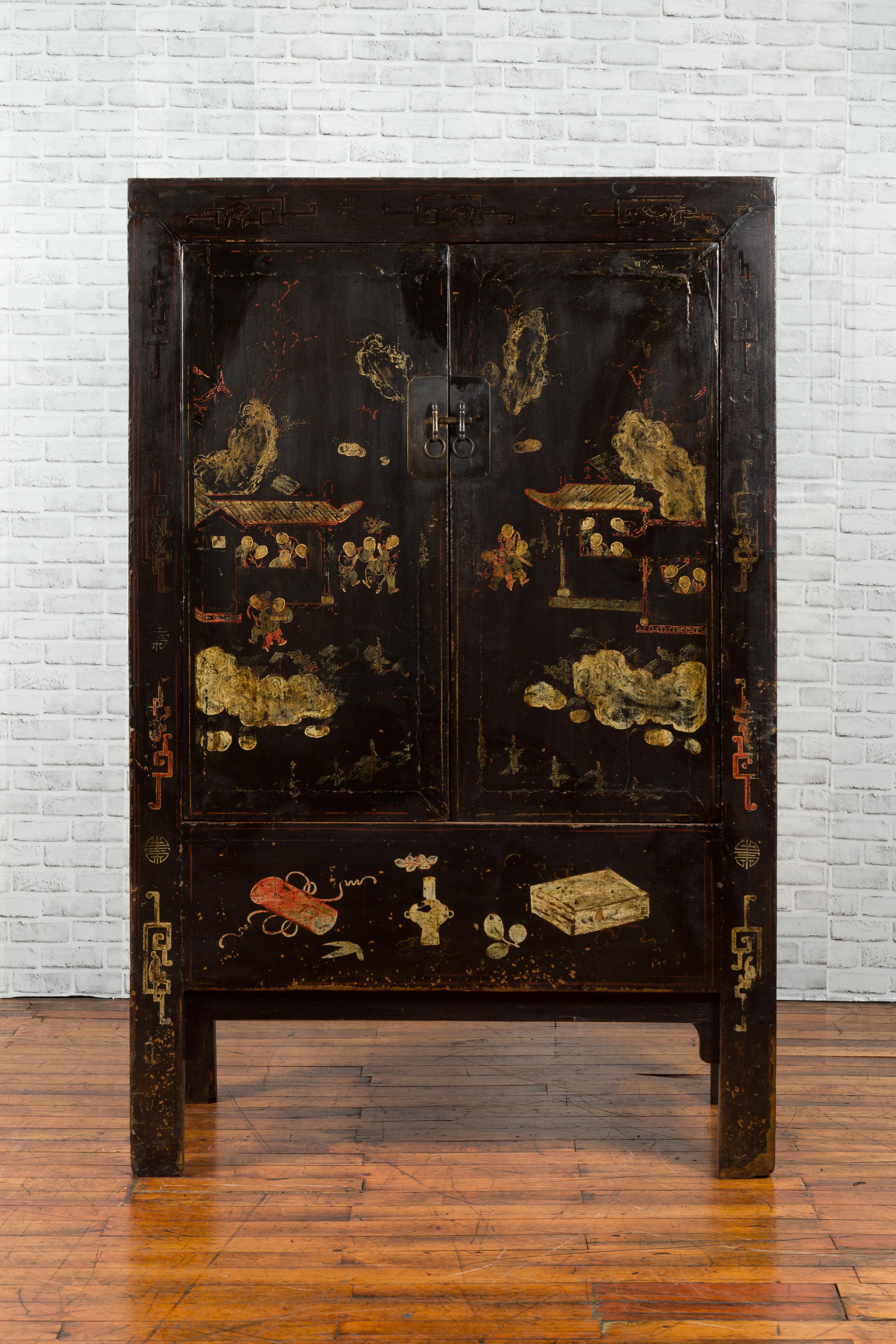 A Qing dynasty two-door elmwood cabinet from the 19th century, with original black lacquer and hand-painted decor. Created during the Qing Dynasty in the 19th century, this exquisite elmwood cabinet showcases its original black lacquered finish,