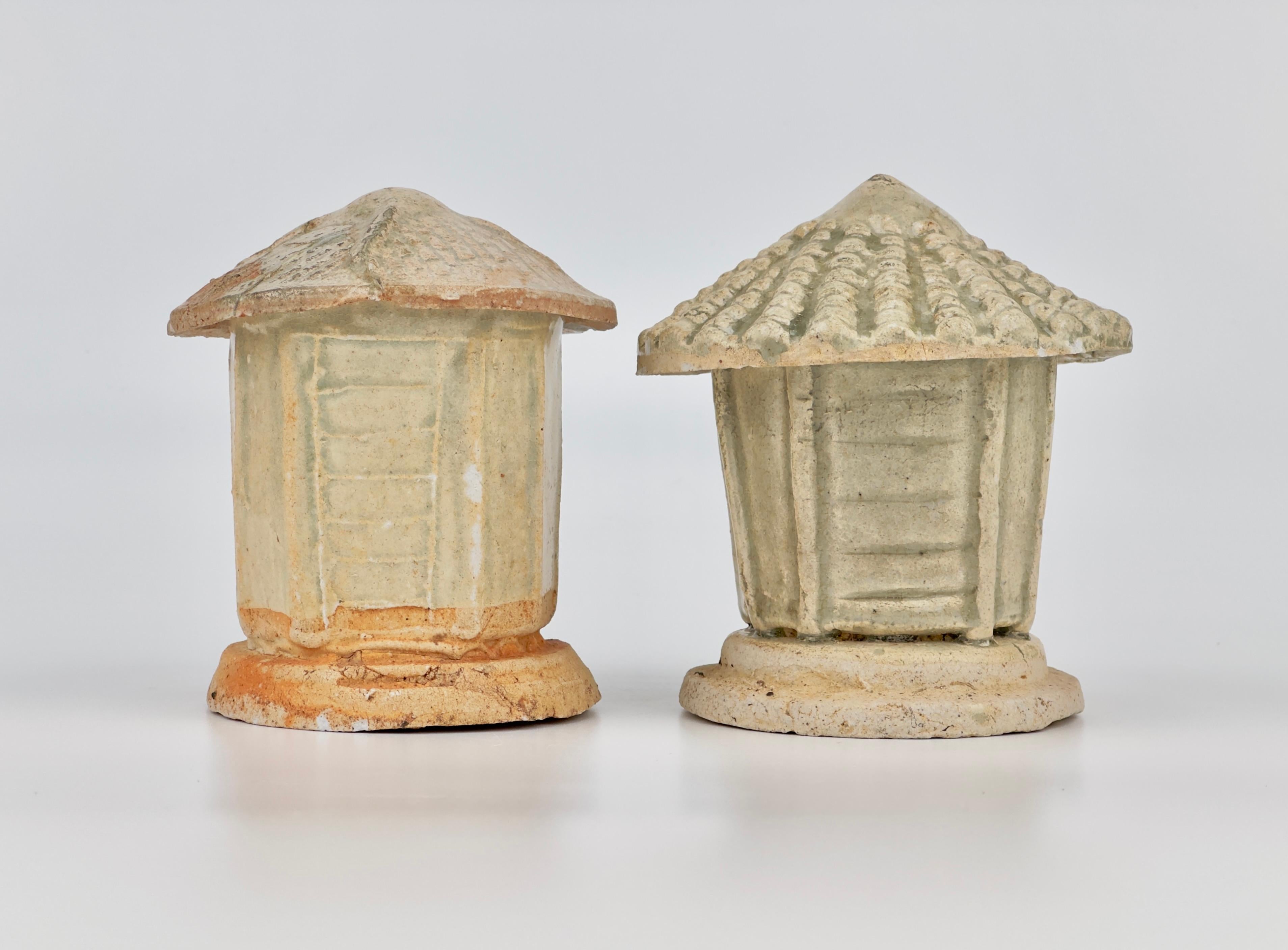 Zwei Porzellanmodelle mit Kornspeicher. Ostasien, Diese Keramikdarstellung eines Getreidespeichers steht auf einem geschichteten Sockel, der von einem konischen Deckel gekrönt wird, der gleichzeitig als Dach dient. Das Ganze ist mit einer für die