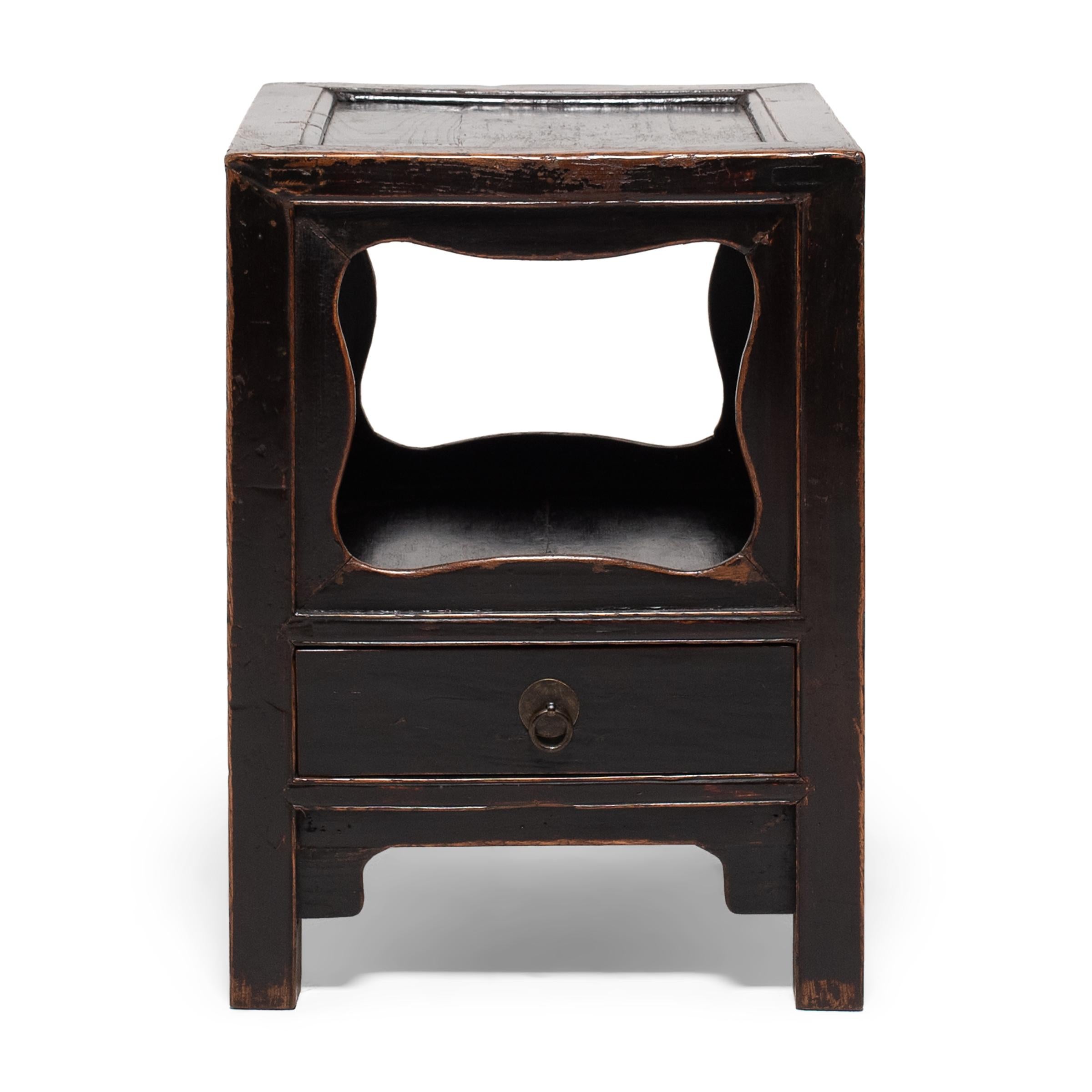 Popular throughout the Qing dynasty, display pedestals such as this were used to display precious objects, serve tea, or elevate burning incense. This square example dates to the mid-19th century and features a lower shelf enclosed on all sides by