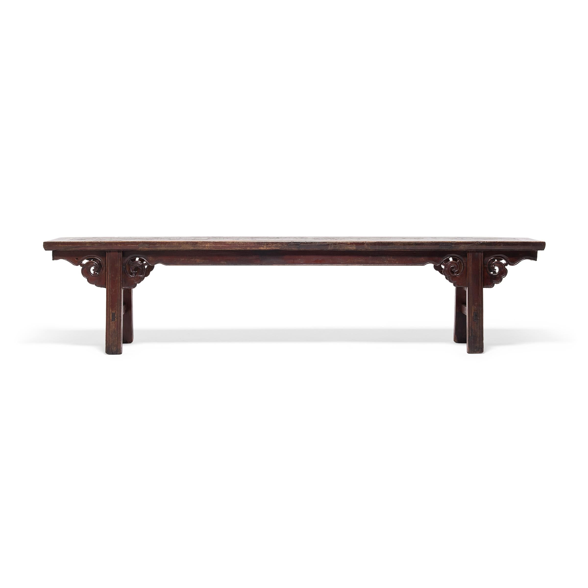 During the Qing dynasty, a preference for ornamentation introduced open work and elaborate carvings to the classic, clean lines of Ming-era furniture. Preserving the best of both styles, this beautifully executed late 19th-century bench unites the