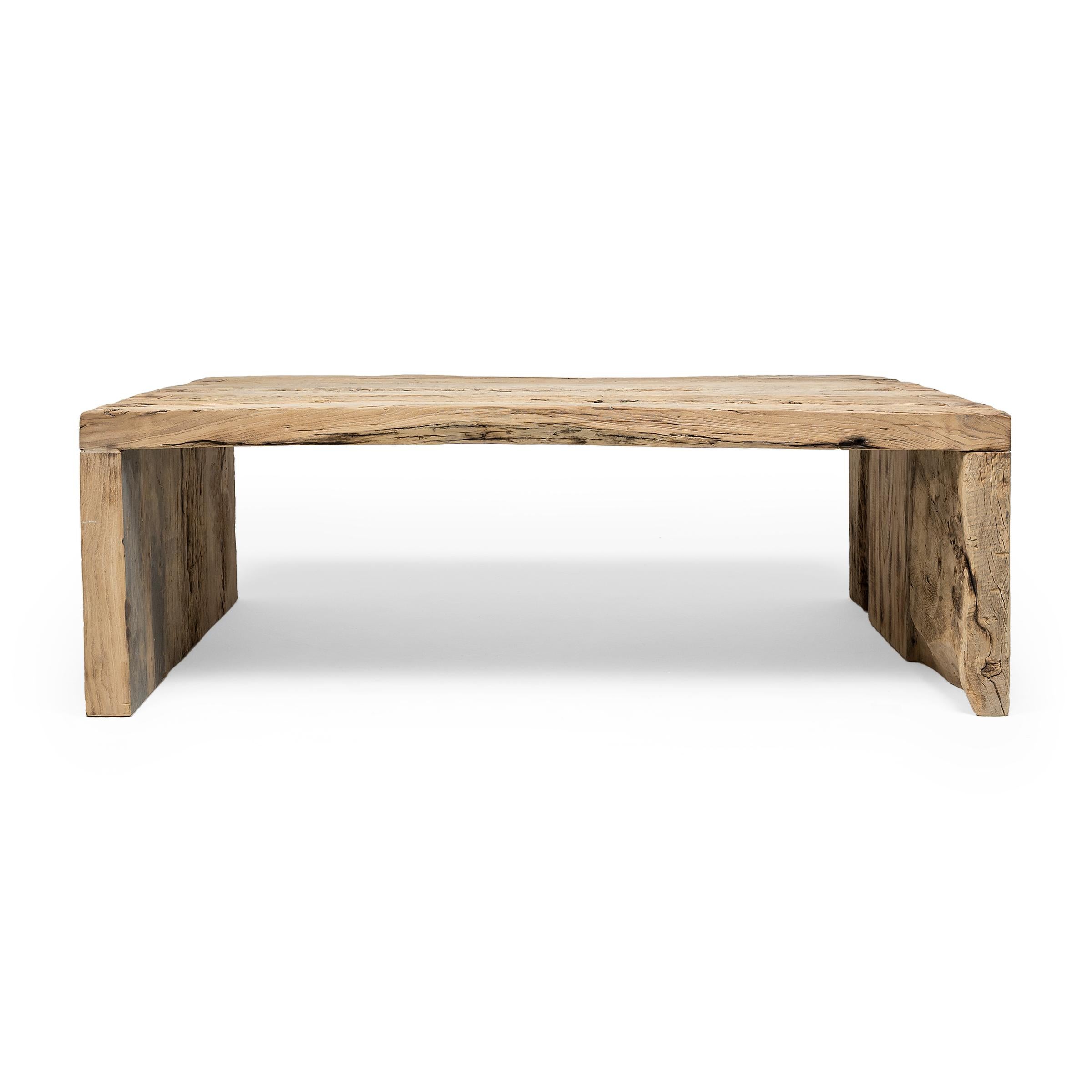 This contemporary coffee table is a celebration of wabi-sabi style. Crafted of Chinese northern elm reclaimed from Qing-dynasty architecture, the table has a minimalist waterfall design and is left unfinished to preserve the natural beauty of its