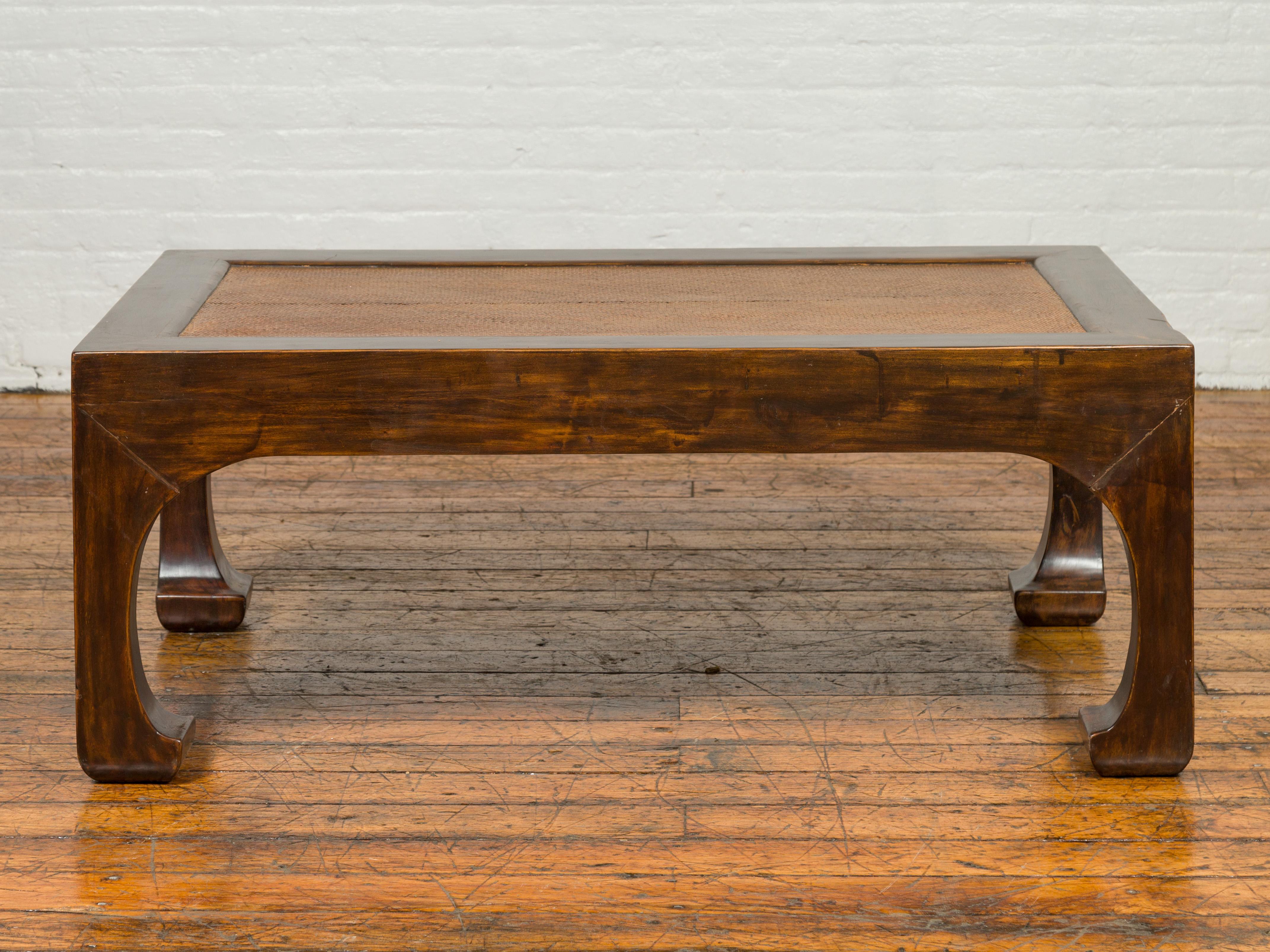 A Chinese rectangular coffee table from the early 20th century, with rattan top and chow legs. Born in China during the early years of the 20th century, this coffee table features a rectangular top with rattan inset, sitting above four eye-catching