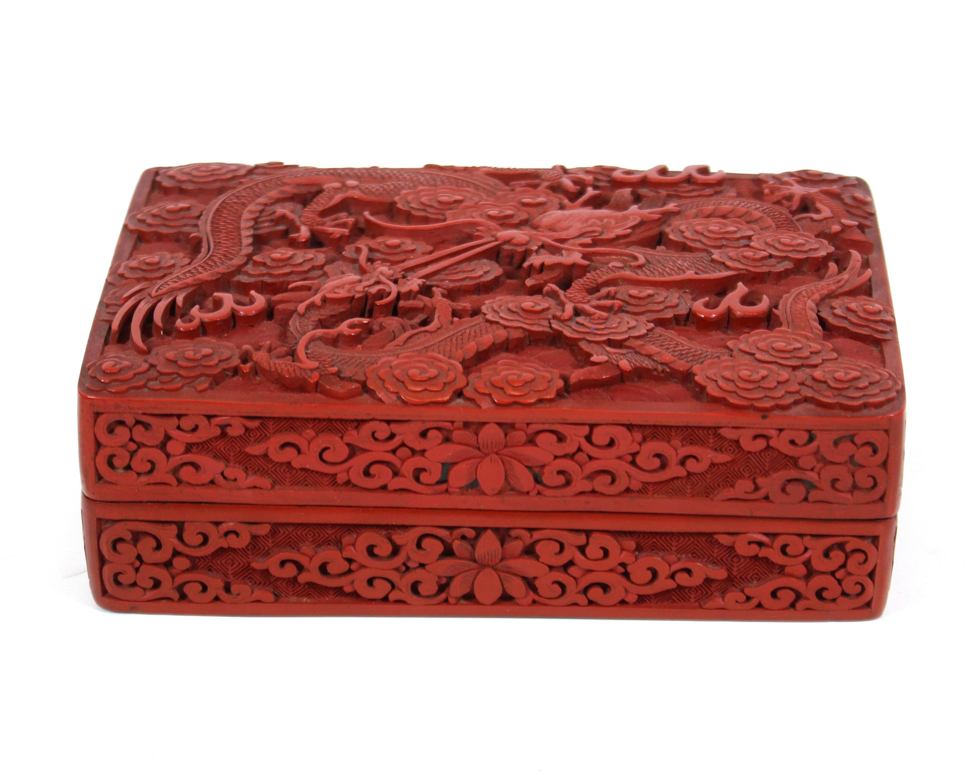 Chinese rectangular hand carved cinnabar bow with dragon motif on the lid. The piece was made in China circa 1900 and has a red exterior and a black lacquered interior. In great antique condition with age-appropriate wear and use.