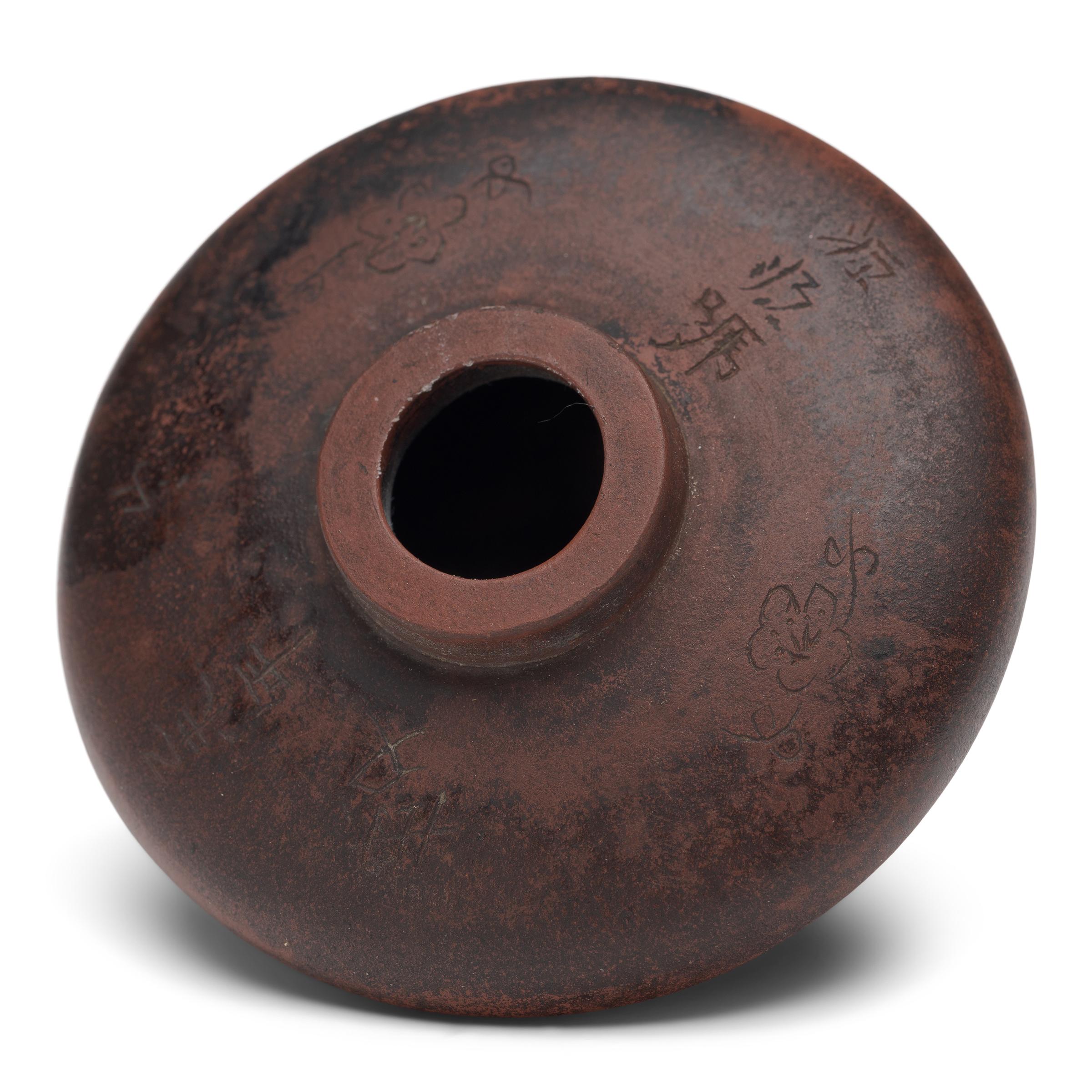 This unusual object is a 19th century opium pipe bowl, beautifully sculpted of yixing red clay to a thin, discus form. Devoid of ornamentation, the refined pipe bowl is decorated only by its burnished patina and the subtle etchings of plum blossoms