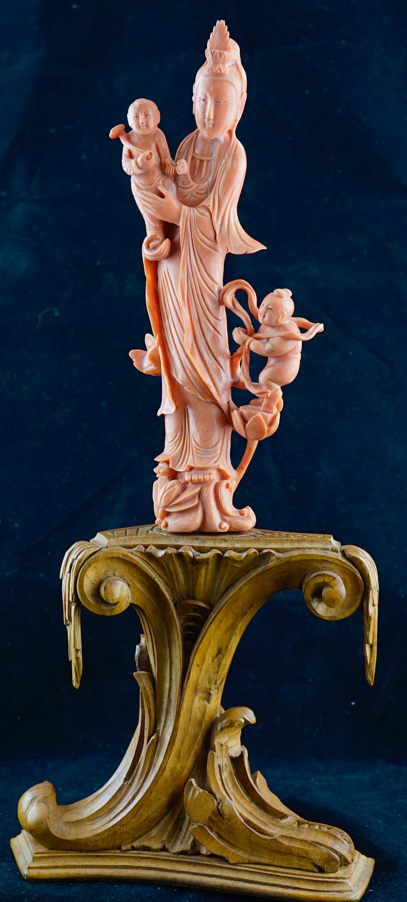 Sculpture chinoise en corail rouge représentant une femme avec des enfants sur une base en bois, 19e siècle. La base a probablement été sculptée dans l'Ouest. Travail très fin et détaillé à la fois sur la figurine et sur la base. La figurine est