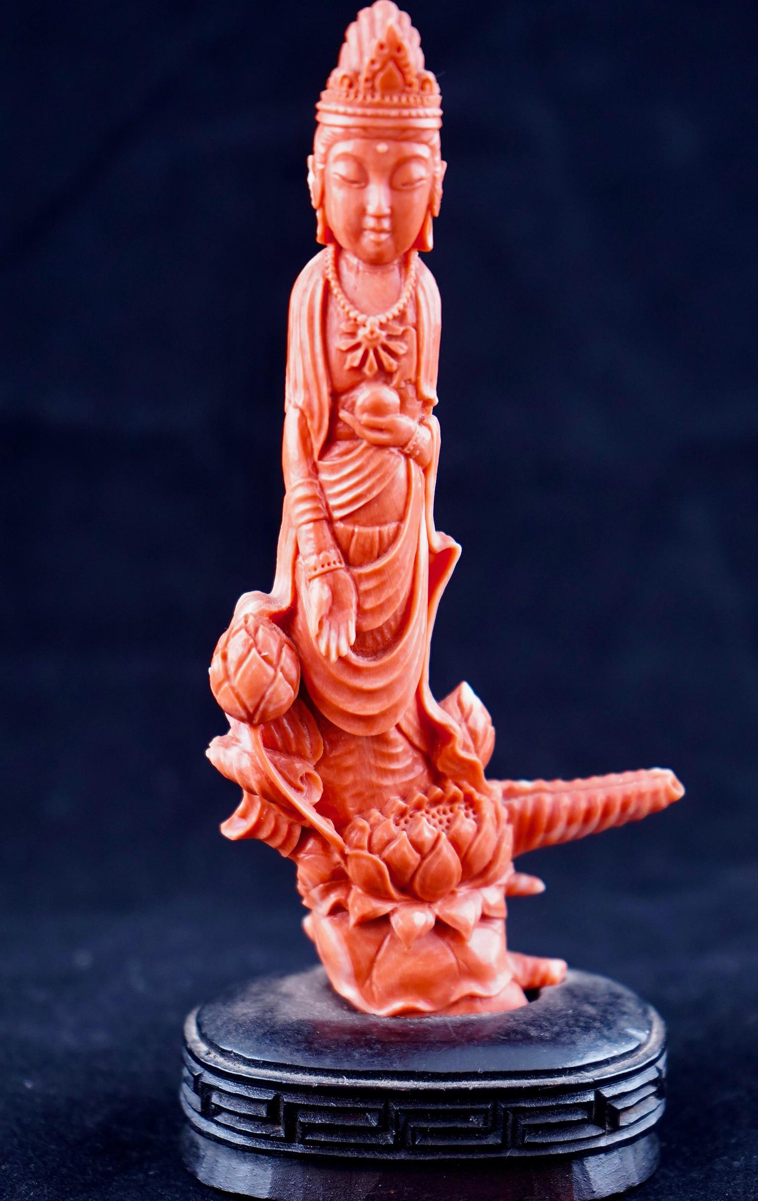 Chinese red coral carving of Kwan Yin over the lotus flower. The figure is attached to the wooden stand with overall dimension 6 