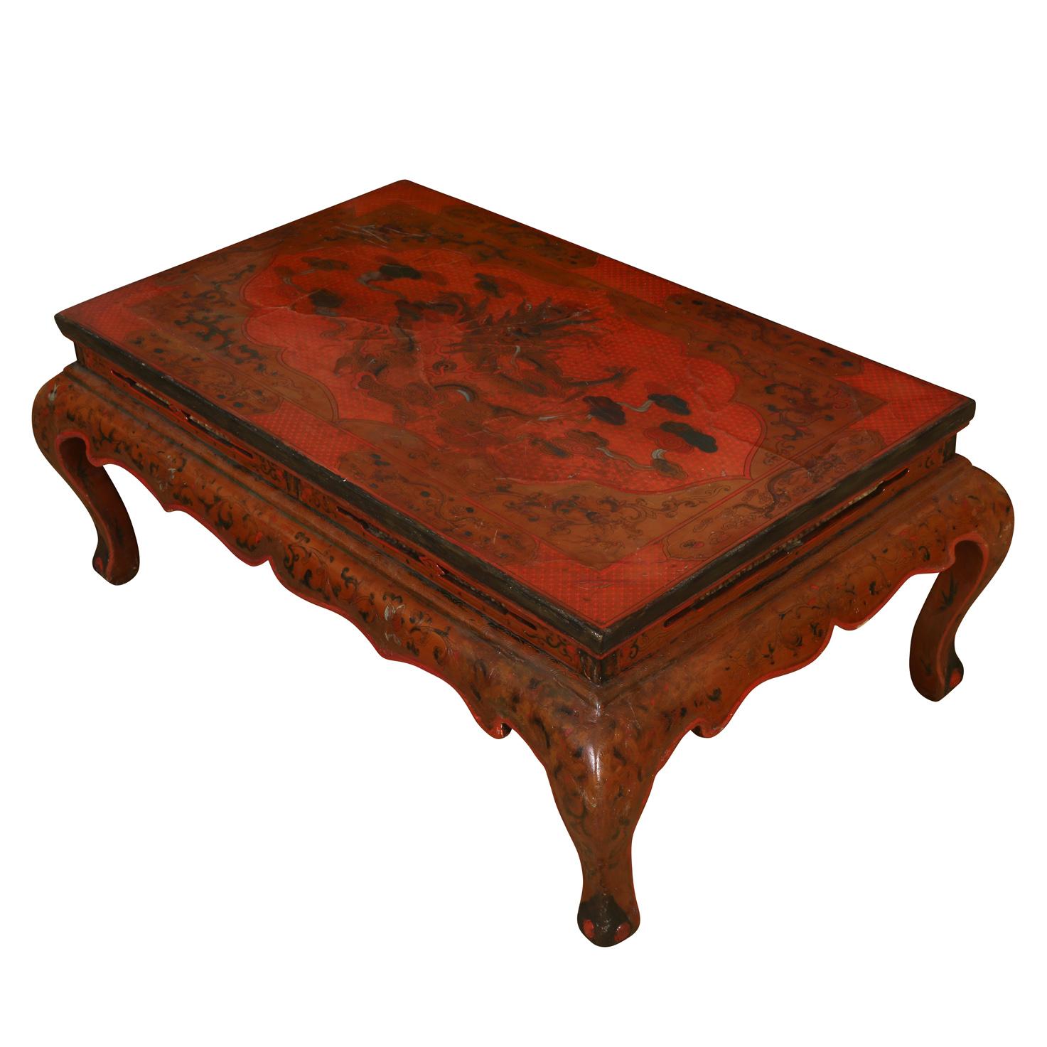 Une table basse chinoise en laque rouge coromandel avec un motif de dragon sur le dessus et des pieds et tablier incurvés.