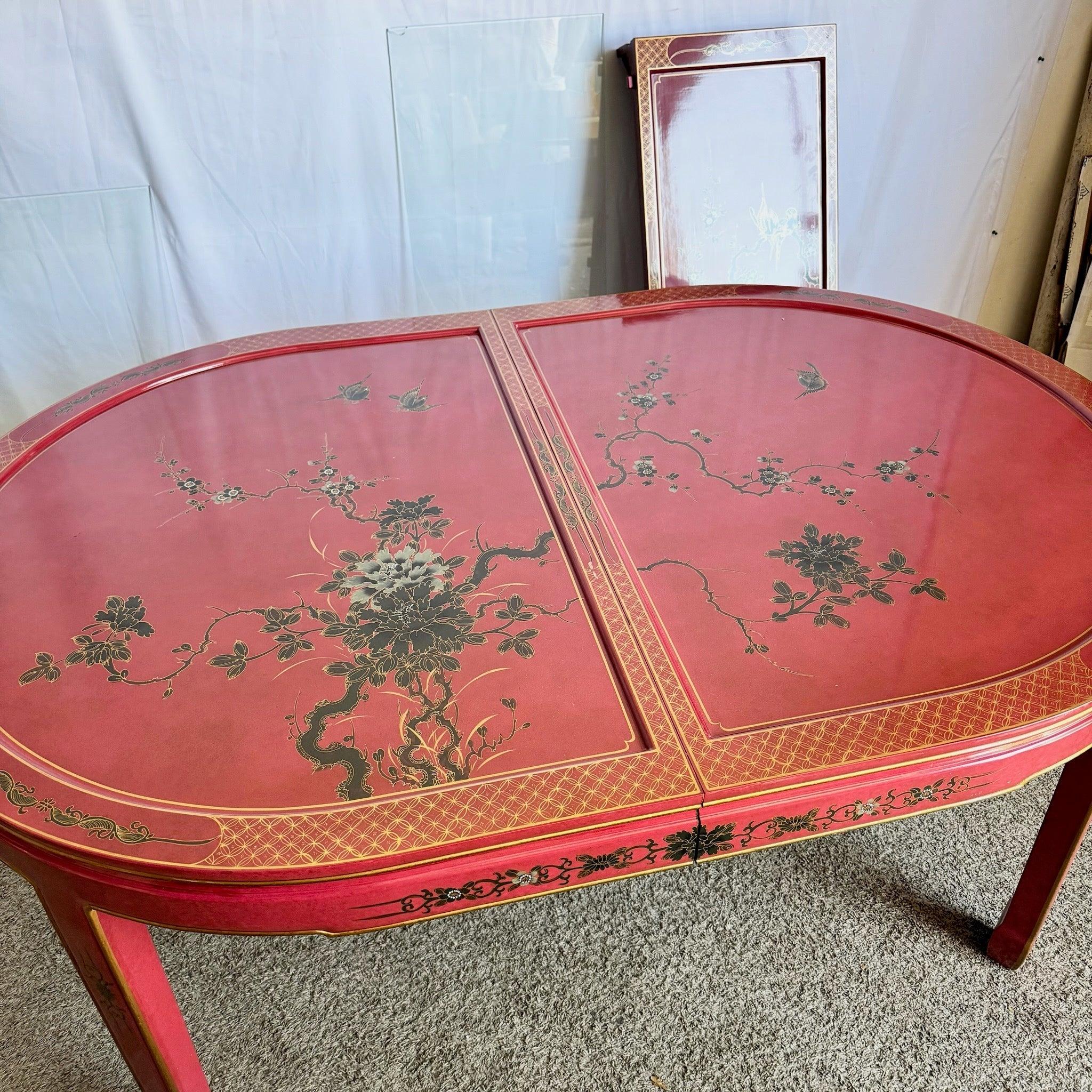 Chinese Red and Gold Lacquered Dining Table with hand-painted botanical art beneath glass—an extendable, luxurious centerpiece that enriches refined dining.
 

 Some wear to the paint on the surface as shown in the photos. A cracked piece of glass